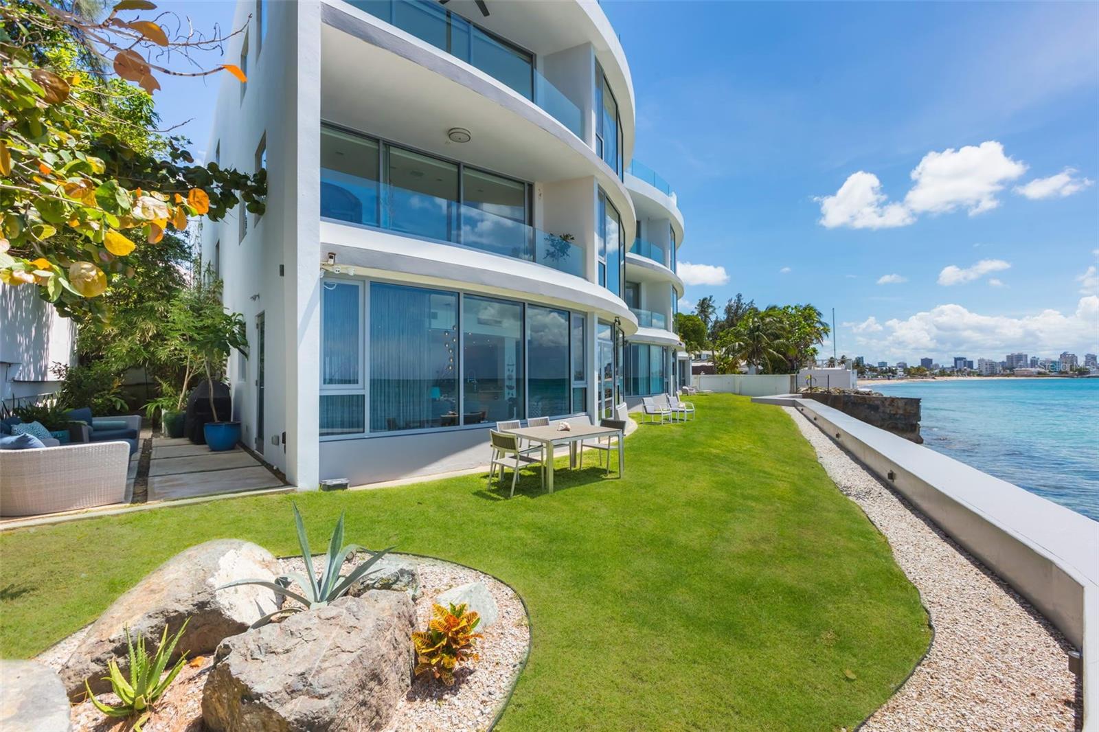 Welcome to Azure Beach at the gated Almendro Street in Punta Las Marias!
This stunning and unique oceanfront garden apartment offers 2,867 square feet of elegant and polished marble floors configured with a spacious living area with floor to ceiling panoramic glass offering vivid views of the Atlantic Ocean and bathing the home with natural sunlight throughout the day. The open kitchen layout also directly overlooks the ocean and includes stainless steel appliances with an oversized fridge/freezer, wine cooler, walk-in pantry, and island seating. The spacious main suite offers picture windows overlooking the private garden and has a large walk-in closet, an open master bath with modern spa tub, large shower, and double sinks. The additional two guest rooms each have ensuite full bathrooms.
A truly unique feature for an oceanfront condominium in San Juan is direct access to the ocean front lawn and beautiful garden from the living area and kitchen. The outdoor garden includes an outdoor shower, BBQ, and a sitting lounge area connected to the green lawn offering spectacular views of Condado and the open water. The lush landscape features automatic sprinklers and discrete landscape lighting so the outdoor spaces can be enjoyed after dark.
The apartment is sold "move-in ready", including all improvements, upgrades and appliances.
Azure Beach is a resort-style development with a location that would be impossible to duplicate today. Residents of Azure Beach enjoy the most impressive roof-top of any development in San Juan that includes an infinity pool, hot tub, and spacious terrace for entertainment. Sit and relax while enjoying unparalleled dramatic sunrises and sunsets!