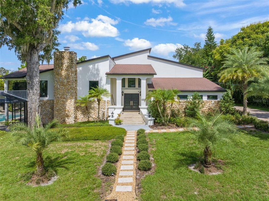 A new long elegantly paved driveway leads up to this beautifully updated 5-bedroom, 4,200 sq. ft. home in the charming Town of Windermere. With lush views of established landscaping & surrounding trees, this home combines comfort, style, and plenty of space for family and friends. The bright, open kitchen is the heart of the home, featuring granite countertops, stainless steel appliances, and windows that fill the space with natural light. The kitchen flows into the dining area and great room, where vaulted ceilings, a cozy gas fireplace, and warm accent lighting make it the perfect place to gather. Step through the French doors to an oversized balcony overlooking the pool and privacy landscaping. The private master suite sits on its own level with a large sitting/dressing area and a personal balcony—a true retreat at the end of the day. On the main floor, you’ll find two more bedrooms, a full bath, and a convenient laundry room. The lower level offers a spacious entertainment area, an en-suite bedroom, an additional full bath, and a fifth bedroom which is currently serving as a stylish home gym. All open directly to the pool deck and fenced backyard, creating an easy flow for family fun and entertaining. Modern updates include Control4 home automation, Nest thermostats for all three AC units, energy-efficient new windows & doors and abundant landscaping. The home has recently been thoroughly redecorated throughout so is move in ready. Living in Windermere means more than just owning a home—you’ll enjoy access to town boat ramps, parks, and scenic docks. Plus, it’s just a short walk to the weekly Farmer’s Market and monthly Food Truck nights, where neighbors come together to enjoy the best of small-town living. This home has it all: space, comfort, and a welcoming community. Come see it for yourself—you’ll feel right at home the moment you arrive.