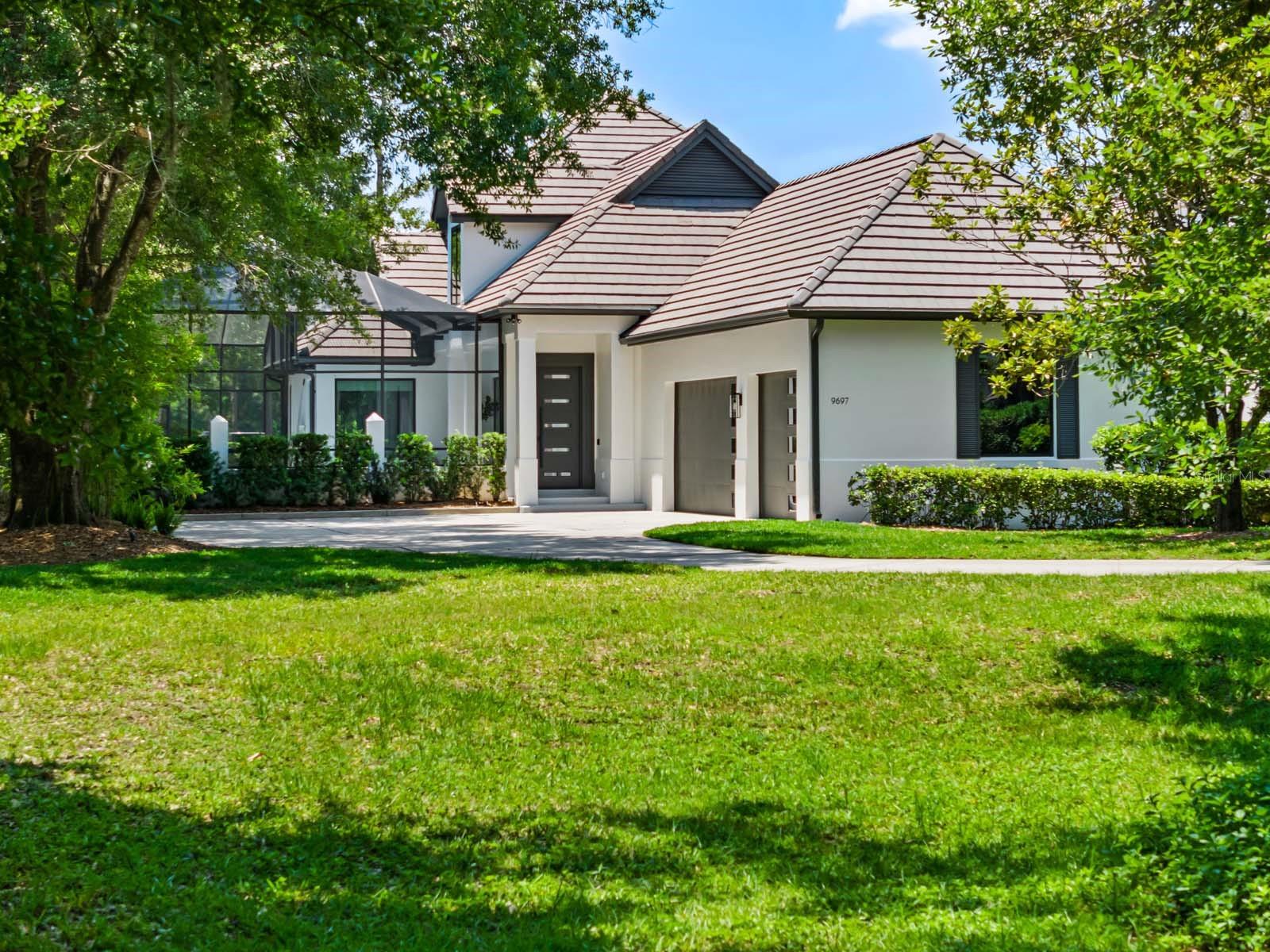 Breathtaking views of Lake Nona’s championship golf course are captured from nearly every vantage point of this newly remodeled home. With the ultimate private setting, located down a winding driveway at the end of a cul-de-sac, this contemporary courtyard residence features four bedrooms, including two owner’s suites, four full and one-half bathrooms. The first floor has been completely reimagined and the warm, yet modern, aesthetic strikes the perfect balance between function and beauty. Guests are greeted by an exterior courtyard offering a screened lanai with refinished pool and spa. From the lanai, the home opens to the expansive living room and a new, gourmet kitchen featuring floor-to-ceiling cabinetry, top-of-the-line appliances, custom backsplash, a waterfall island, and dining space. Tile flooring from Spain travels throughout the home, adding a touch of European elegance. The downstairs owner’s suite features a stunning bathroom redesigned as a private spa experience. The home’s most comfortable gathering space, the living room, offers ample room for large gatherings and opens to a covered patio with new retractable screens and sensational golf and water views. Panoramic views can also be enjoyed from the spacious balcony located just outside the second-level owner’s suite. The upstairs level boasts a versatile loft and an office area perfect for work or study. One of the unique features of this property is its expansive frontage as you enter the driveway - The seller has preliminary builder plans for a two-story guesthouse in this location, available upon request. Additional features include: New Windows and Exterior Doors; First Floor Laundry Room; 3-Car Garage.