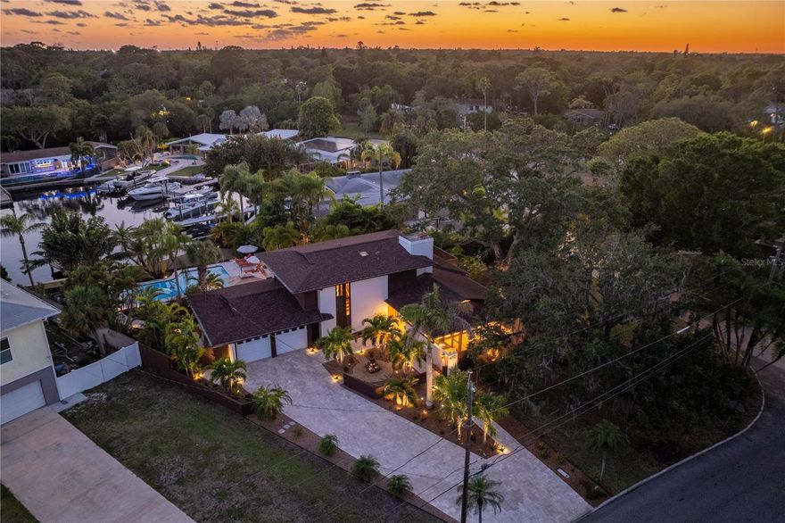 *** ABSOLUTELY STUNNING MID-CENTURY MODERN *** This Frank Lloyd Wright Prairie Home design architected by renown Harvard Jolly Architecture is situated on a very large corner lot with 75’ of waterfront on Fernery Bay. The home has been completely updated and modernized with an exceptional attention to preserving the key architectural elements of the original design. Mitered glass windows and doors connect the indoors with wraparound re-screened porches abounding light, airflow, and the feel of Old Florida. The interior wood banding, organic elements, and recessed wood soffits have been completely refinished. The floated, smooth ceilings in combination with LED Uplighting, Art Track Lighting, and extensive recessed lighting provide a striking impact. New Travertine Shell Stone flooring extends throughout the first floor living, dining, kitchen, bedroom, laundry, and pantry. The pool bar has a second refrigerator and dishwasher, ice maker, wine cooler and seating area. Hardwood stairs lead up to an entertaining Loft or an office, guest bedroom, and the en-suite Primary Bedroom with a large walk-in custom closet and newly remodeled Bath with dual sinks, deep tub and shower wet room. Motorized blinds, speakers with surround sound, and new door hardware are just a few of the many upgrades made to this home. And no truly 21st century home would be complete without a Smart Home system which remotely controls lighting, blinds, music, temperature, security, door bell, locks, irrigation, and some appliances via an app. The enormous chef’s kitchen has been expanded and completely remodeled with solid Cherry cabinetry, granite countertops matched throughout the home, Arto Custom Bow Tie backsplash and a very large island, with power and USB ports. Commercial style appliances including a 5 Starr dual fuel, 6 burner stove with double ovens and matching 5 Starr hood complete the kitchen. A finished, spacious 2 car garage with resurfaced flooring and travertine driveway with additional parking provide plenty of room for you and your guests. Outside, you’ll find a refinished 34’ pool with travertine decking overlooking the water. The extraordinary landscape lighting, gardens, fountains, and seating areas all offer wonderful outdoor entertainment options. All improvements including the roof, seawall, dock, gutters, fences, and pavers have been upgraded over the last 5 years. Fernery Bay has unfettered access to Tampa Bay and the Gulf of Mexico with no bridges. All this and so much more, only your personal tour will reveal the numerous improvements to this most gorgeous home.