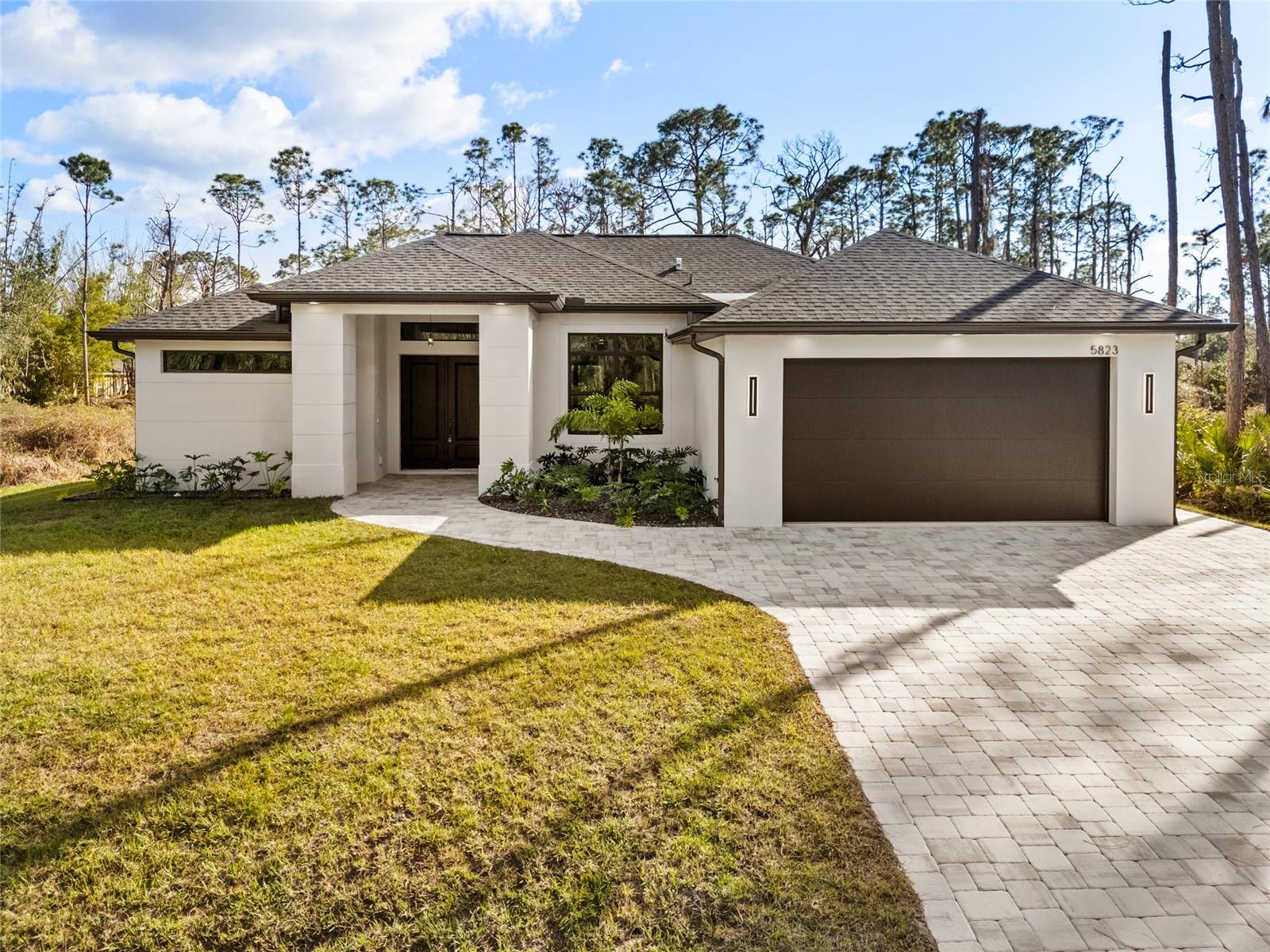 Newly Custom Built Home Completed in an impeccable neighborhood. This Custom Home offers a perfect blend of style, function, and convenience, with Oaks Park at a walking distance, and the highway just minutes away. No upgrades were spared on this luxurious 1,789 square foot living home. Soaring designer ceilings, natural Quartz countertops, high 12 foot tray ceilings throughout, walk in closets, decorative designer light fixtures, real wood facing cabinets, tinted double pane hurricane windows, paved driveway, and wrap around shower are just the start of the upgrades on this home. Feature 3 bedrooms 2 Bath with custom engineered wood glued down flooring and 2 car custom insulated garage door, this home offers space for the whole family to spread out. Open layout allows for large gatherings. Prewired and pre plumbed for possible outdoor kitchen in the large lanai. Beautiful Greenbelt in back of home permits you to enjoy up to 60' of privacy.