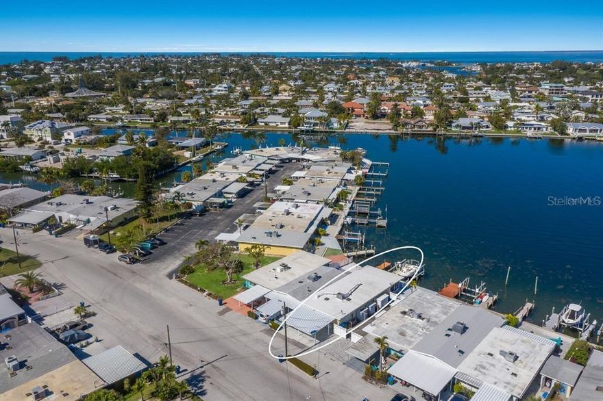 Welcome to Villa Mar! A luxury vacation rental directly on Watsons Bayou with open water views. This completely renovated 2BD/2BA corner villa is the largest floor plan in Seaside Gardens and features updated kitchen with waterfall counter, brand new appliances, luxury baths, oversized wood plank tile throughout, impact windows and doors, great storage, newer AC, new roof, and 7 inch PVC baseboards for peace of mind. This lot has an extra wide 2 car carport with built in storage cabinets and shed. A large screened patio is perfect for outdoor entertaining after a long day on the boat. A 27 foot boat dock with electric/water, fish cleaning station and 10,000 lb boat lift complete the package. Great location with tennis, shuffleboard, pickle ball and the dog park just steps away. Active weekly rental business! No HOA and no condo fees. Seaside Gardens is a historic civic association maintaining the communal spaces and a low monthly fee of only $150 includes sewer and water. This is the perfect island getaway!