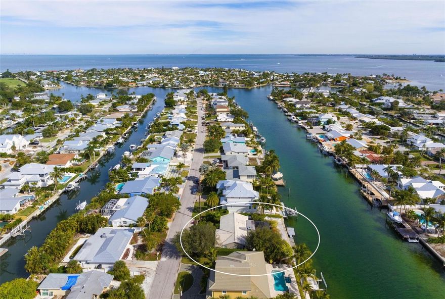 The Grand Canal! Experience a captivating waterfront lifestyle in a charming bungalow nestled on a lushly landscaped 8,240-square-foot lot along the coveted Grand Canal. Boating enthusiasts will delight in the extensive dock and direct access to Tampa Bay and the Gulf of Mexico. The 3-bedroom, 2-bathroom home boasts brand-new hurricane-resistant windows and doors throughout, including new sliding doors to a covered patio and canal-front pool. The generously sized primary bedroom includes an en-suite bath. While the 1952-built home currently occupies the lot, this property offers an opportunity for either renovating the existing home or starting anew to create your waterfront dream home. The property is in a monthly rental neighborhood and  is close to the private Key Royale Club, which offers the island’s only golf course, along with dining and social activities. Situated just a golf cart ride away from Anna Maria Island's pristine beaches and various points of interest, this incredible location allows you to fully immerse yourself in the island's fabulous lifestyle. Don't miss the chance to explore this property – call now to schedule your private showing.