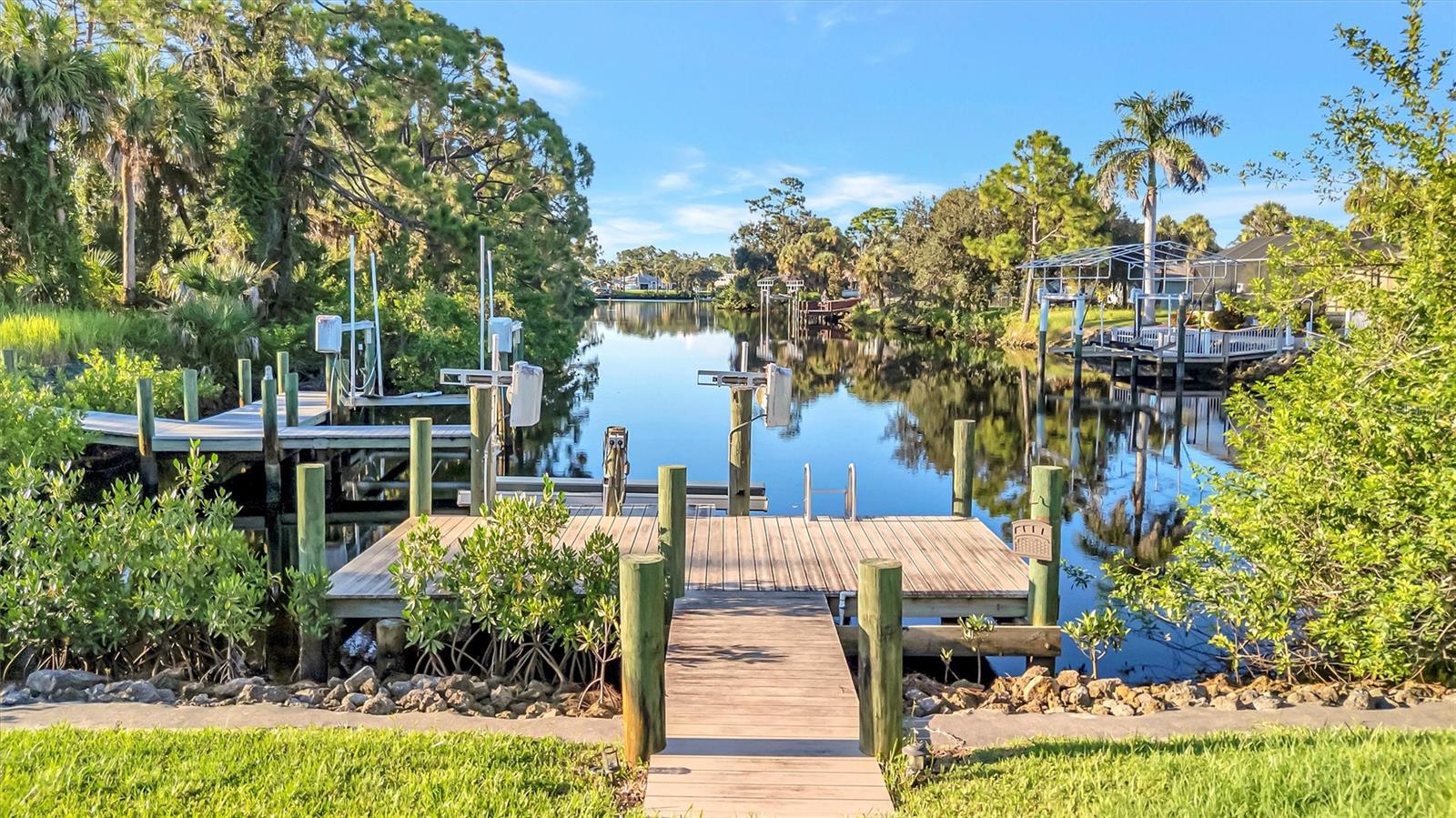 Experience waterfront living at its finest. This beautifully maintained, one-owner pool home offers breathtaking long water-views from your backyard oasis. Nestled on an oversized, nature-surrounded lot with no rear or side neighbors, you’ll enjoy peace, privacy, and serenity every day. The roof was replaced in 2023 and AC replaced in 2018 plus new carpeting in 2025! Inside, an open and airy floorplan greets you with an abundance of natural light, thanks to expansive windows and sliding walls of glass that bring the outdoors in. The spacious layout includes three bedrooms, two bathrooms, a large kitchen with café dining area, and a split bedroom design for added privacy. The oversized garage complete with workbench is sure to please the handiman in the home. Relax on the screened lanai, take a dip in the pool, and enjoy tranquil wooded views that make this home feel like a true getaway. And with no HOA, you’ll have the freedom to make it your own — whether you're ready to move right in or customize to your heart's content. A rebuilt dock (2016) with a 4,500 lb boat lift is ready for your next adventure — Boating enthusiasts and fisherman alike will enjoy cruising the Cheshire Waterway with direct access to Charlotte Harbor, the Myakka River, and the Gulf of Mexico. Spend your days exploring Pine Island, Sanibel, Captiva, Boca Grande, and beyond. Sports fans will also appreciate being just a short drive from spring training games with the Tampa Bay Rays and Atlanta Braves nearby. This is Florida waterfront living at its best — come see it for yourself!