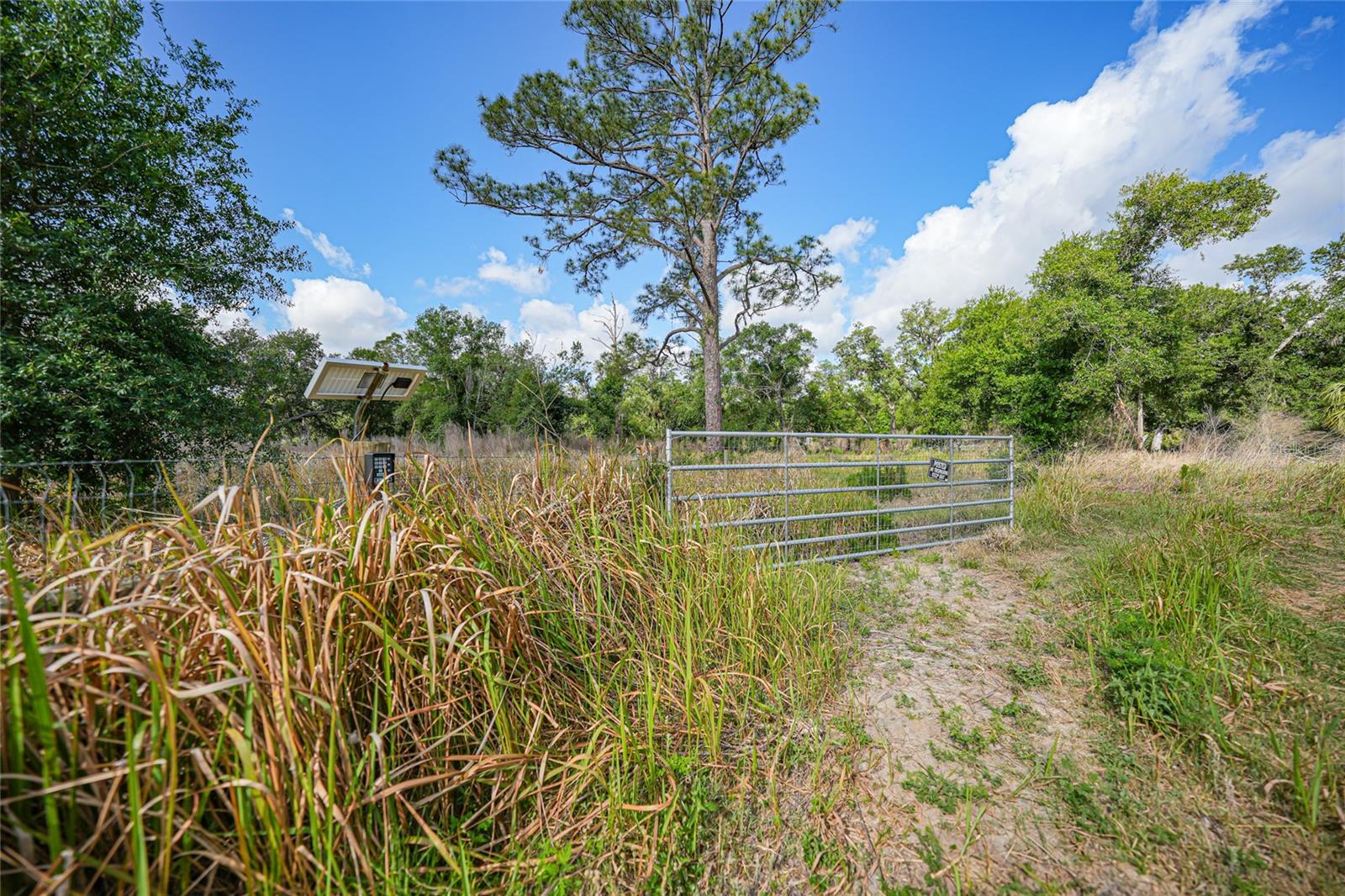 If you’ve been dreaming about starting a mini farm, building a cozy homestead, or just pressing pause on the chaos of everyday life... this property might just be your perfect fresh start. Located in the peaceful Royal Park Estates, this just-under-an-acre lot is fully fenced, gated, and absolutely packed with potential. The land strikes the perfect balance—open, cleared space for your animals or garden beds, mixed with gorgeous oak trees for shade and that peaceful, old-Florida charm. There's a newer artesian well already in place, complete with a UV purification system, and the gated entrance features a solar-powered Ghost Controls system with remote access. A garden shed and carport are already on-site, and you’ll even find fruit trees sprinkled across the property, just waiting to be part of your homestead story. Here’s where it gets even better: the seller is including a fully renovated Farm Bus—yep, a bus—complete with bamboo flooring, solar power, and everything you need to live comfortably while you build your dream home or take your time and just enjoy the simple life. There’s already a completed elevation certificate and Peace River Electric is posted for power—so no waiting around for the basics. You’re not starting from scratch. You’re starting ahead. This isn’t just land. It’s a lifestyle. And it’s ready when you are.