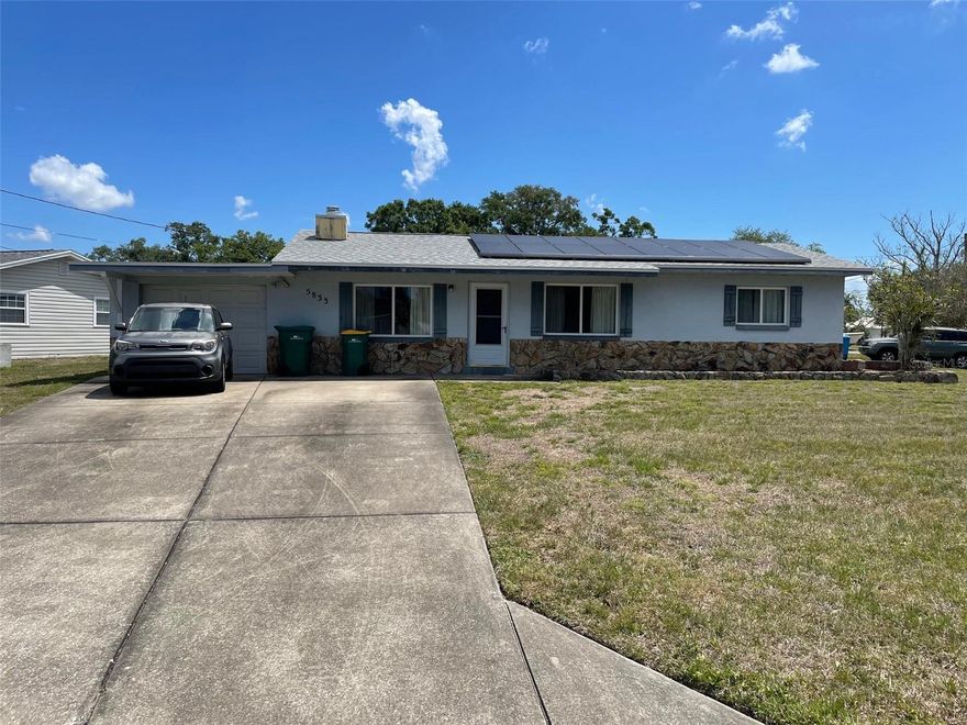 What a great layout in this 2/1/1.   Walk through the front door and to the right are 2 large bedrooms and bathroom.  Walk back through to the kitchen and then the dining area.  Go into the family room with a beautiful stone fireplace.  Off the family room is a laundry room with lots of storage and door to the outside and patio that overlooks the Pond.  This is a large corner lot.  This homes roof was replaced 9/2023, AC 10/2022 and Solar Panels 2017 will be paid off by closing.  This home has never flooded.  Come and make this home our own.  Great sought-after location,