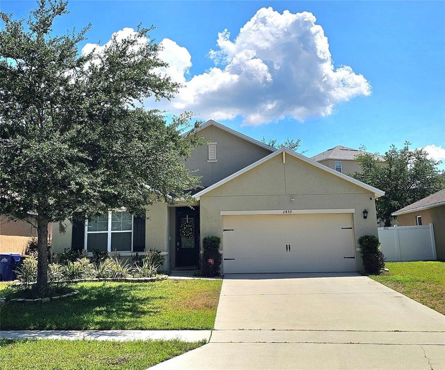 Welcome to this charming home in Lane Park Ridge, a Tavares community tucked away from the hustle and bustle of the big city congestion. This beautifully maintained 4 bedroom, 2 bathroom, 2 car garage, one-story home built in 2018 offers 1,828 sq ft of modern comfort and style complete with an extra large privacy fenced yard. Step inside to find upgraded luxury vinyl flooring flowing through the foyer, kitchen, and spacious family room—perfect for both everyday living and entertaining. The heart of the home features a stunning upgraded kitchen with stone countertops, ample cabinetry, walk-in pantry and an open layout overlooking the large family room complete with a beautifully tiled entertainment wall with built-in fireplace and TV. Retreat to the generously sized owner’s suite, offering comfort and privacy, while three additional bedrooms provide flexibility for family, guests or a home office. Enjoy Florida living at its finest in the screened-in back patio ideal for relaxing mornings or evening gatherings. The huge fully fenced backyard offers exceptional privacy with mature trees, creating a peaceful outdoor oasis with plenty of room for entertaining, lots of space for the pets or enough land for future additions like a pool. Located in the charming and growing city of Tavares, known as “America’s Seaplane City” you’ll enjoy a relaxed lifestyle with nearby fishing, boating, and scenic kayak tours along the Dora Canal. Just minutes away, downtown Tavares offers brick-lined streets, waterfront dining, boutique shopping, and lively nightly entertainment. This move-in ready home blends modern upgrades, outdoor space and a prime location. Don’t miss your opportunity to own this exceptional property with plenty of upgrades!