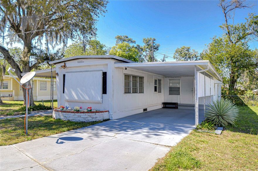 Near the clubhouse for your convenience. Enter into the enclosed porch or Florida room and on into the home. You have an open
area of the furnished living room and kitchen with an eating area.  The home is furnished. You only need to bring your personal items.
Down the hall are smaller storage closets or maybe even a pantry. The hall bath has a tub with a shower and a linen closet.  The
bedroom at the end of the hall has a built in closet and built in dresser and vanity area. To the right of the hall is the addition with a
large bedroom and another bathroom with a tub with a shower. Off of the Florida
room there is a workshop area. Out back there is a shed attached with the laundry area. This home has a carport and driveway for
parking.  Call now for an appointment to view this home.