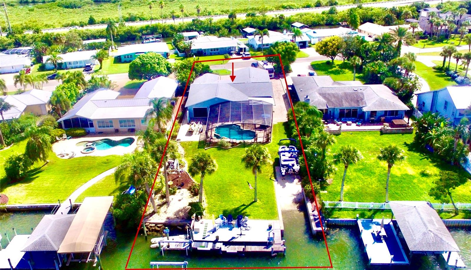 Coastal living with 76’ of Deep Water frontage directly on the Intracoastal waterway. Plus your private 10’ wide boat launch,13,000 LB boat lift, large swimming pool and spa. You cannot find a better location than this! Centrally located in beautiful New Smyrna Beach on a quiet cul-de-sac just moments away from the sandy beach, famous Flagler Avenue and historic Canal Street. A home with a panoramic view and amazing sunsets. Walk into a home with exquisite hardwood cherry flooring installed in 2015, the large foyer has custom wood book-shelves and a Murphy bed. This spectacular home is perfect for the entire family! Not only does this home have everything for the boating enthusiast it also has plenty of room for entertaining friends and family. The home is currently set up to sleep up to 11 people comfortably. The delightful designer kitchen with tray ceiling, countertop seating, quartz countertops, wood cabinetry, and top of the line stainless steel appliances completed in 2015. The kitchen opens up to the dining area overlooking the large screened outdoor kitchen, pool and spa area with plenty of seating overlooking the Intracoastal waterway. The beautifully landscaped garden is complete with an Olive tree, two Mulberry bushes and pineapple plants. The primary bedroom has a private en-suite bath and an adjacent room that can be used as a dressing room, office or craft room with closets, the guest bedroom also has a private en-suite bathroom. The bunk bed/kid room with a closet and laundry facilities is located just off the kitchen. The Riverview third bedroom/office is located to the east of the main living room with views of the intracoastal waterway. The room has a garage door and motorized screen to enjoy the river breezes. This home is on a very large lot that can accommodate parking for up to 8 to 10 vehicles plus an oversized 2 car garage. Renovations adding the master bedroom and 2 car garage that was completed between 1995 and 1999. New Roof 2022, 2 A/C units new 2022 and 2023, updated reinforced seawall 2023, propane heated Spa (spa heater 2 years old), plus new tankless water heater 2025. Location Location, Location walk, bike or short drive to the soft sandy beach, 1 mile to the famous Flagler Avenue with shopping, restaurants, bars and nightlife or 1 mile west to Canal Street with more shops, restaurants and bars. This home is a must see to truly experience the beauty, functionality and the perfect location here in New Smyrna Beach.