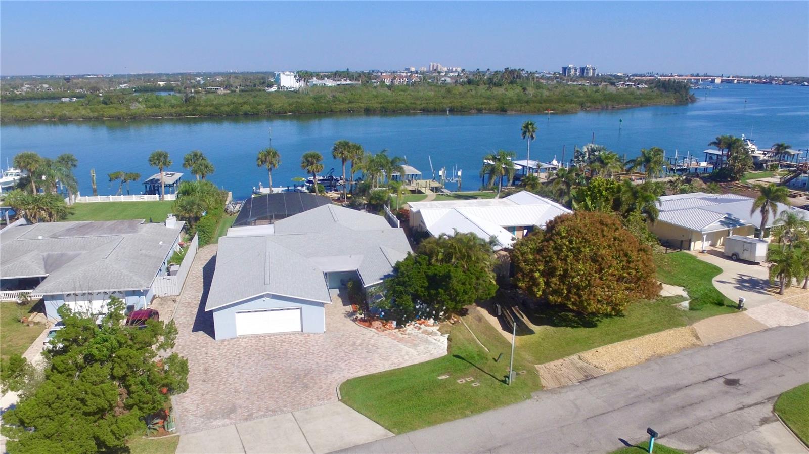 LOOKING FOR DEEP WATER? 70' DEEP WATERFRONT ON THE INTRACOASTAL WATERWAY OF NEW SMYRNA BEACH WITH A PRIVATE BOAT RAMP, 13,000 LB BOAT LIFT, LARGE SWIMMING POOL AND GAS HEATED SPA. A HOME WITH A BEAUTIFUL VIEW. Centrally located on a quiet cul-de-sac and about 2 miles by boat to the famous Ponce Inlet with access to the Atlantic Ocean. This spectacular home is perfect for the entire family! Not only does this home have everything for the boating enthusiast it also has plenty of room for entertaining friends and family with the large screened outdoor kitchen, pool/hot tub area with plenty of seating overlooking the beautifully landscaped garden complete with a Olive tree and two Mulberry bushes all with unobstructed views of the intracoastal waterway where you will see the occasional frolicking dolphin. This home is a must see. The delightful designer kitchen with tray ceiling, quartz counter tops and top of the line stainless steel appliances opens up to the dining area overlooking the outdoor covered seating area and outdoor kitchen truly a chefs delight. This beautiful large home has so much and more with exquisite hardwood cherry flooring, a grand living room with views of the Intracoastal Waterway and your private pool and hot tub. The primary bedroom has a en-suite bath and an adjacent room that can be used as a dressing room or bedroom with closets, guest bedroom with en-suite bathroom, bunk bed room with closet and laundry facilities, large foyer with wood book shelves and Murphy bed, a flex room, office or boat equipment storage room is located off of the main living room with views of the intracoastal waterway has a garage door and motorized screen to enjoy the river breezes. The very large lot and home has an oversized 2 car garage with plenty of parking for up to 8 to 10 vehicles. This home is truly an oasis. New Roof 2022, 2 A/C units new 2022 and 2023, updated reinforced seawall 2023, propane heated Spa (spa heater 2 years old), plus new tankless water heater 2025. Location Location Location walk, bike or short drive to the soft sandy beach, 1 mile to the famous Flagler Avenue with Shopping, Restaurants, Bars and Nightlife or 1 mile west to Canal Street with more Shops, Restaurants and Bars. This home is a must see to truly experience the beauty, functionality and the perfect location here in New Smyrna Beach.