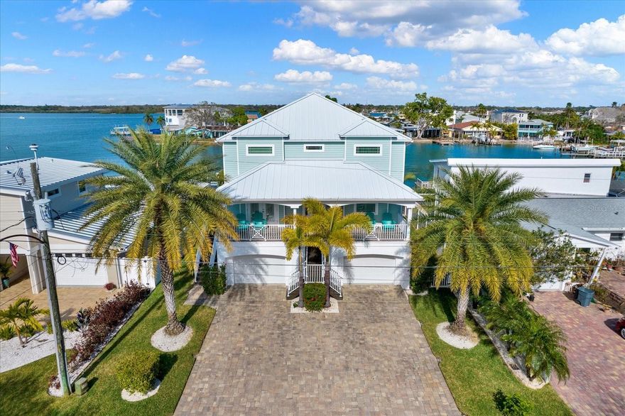 PARADISE FOUND! IMPRESSIVE DOESN’T EVEN BEGIN TO DESCRIBE THE MAGNIFICENT INTERIOR AND EXTERIOR OF THIS 4BR/3.5BA WATERFRONT HOME IN THE HEART OF REDINGTON BEACH! BUILT IN 2012, THIS KEY WEST STYLE HOME OFFERS OVER 2,700 SQ FT OF TIMELESSLY BEAUTIFUL LIVING SPACE WITH UPGRADES GALORE! Boasting deep boating water, BIG VIEWS, and a location that’s MINUTES to the Gulf of Mexico by boat, this home is move-in ready and won’t last long! Step inside and enjoy beautiful wood floors throughout, high ceilings, an ELEVATOR, and tons of upgrades such as crown molding throughout and IMPACT WINDOWS AND DOORS! The OPEN-CONCEPT KITCHEN is a chef’s dream, with a gas range, solid wood cabinetry, stone tile backsplash, granite counters and stainless appliances. Adjacent to the kitchen is a FORMAL DINING ROOM on one side and a breakfast nook on the other overlooking fabulous water views! The spacious living room is drenched in natural sunlight and opens up to a huge covered patio with dazzling water views and plenty of space for al fresco dining. Upstairs, the expansive primary bedroom is a true waterfront retreat away from it all, with UNPARALLELED VIEWS OF THE INTRACOASTAL WATERWAY from every angle, plus a PRIVATE COVERED PATIO, walk-in closet and secondary closet, and a luxurious primary bath with walk-in shower, ceiling heat, and jetted tub overlooking even more water views! There are 2 more guest bedrooms upstairs, plus a large laundry room, complete with a washer/dryer set. Downstairs, there is a 3rd guest bedroom with an en suite bath in impeccable condition. This home has an oversized 2-car garage with double bays, PLUS A LARGE INTERIOR WORKSHOP that’s perfect for a variety of hobbies, a home gym and more. Outside, the backyard is a boater’s paradise with a 10,000LB BOAT LIFT, DAVIT, KAYAK AND JET SKI LIFTS! The composite dock was installed in 2019 and has water and electric, plus a NEW SEAWALL IN 2021. The resort-style saltwater pool is surrounded by a HUGE PAVER PATIO, outdoor shower, and a large covered patio that’s perfect for outdoor entertaining.  Other desirable features include a long-lasting metal roof, a WHOLE HOUSE GENERATOR, a new pool pump, NEW HVAC IN 2021, 12-inch insulation in the attic, water filters under the kitchen & bathroom sinks, and TONS OF STORAGE throughout. See this home today before it’s gone!