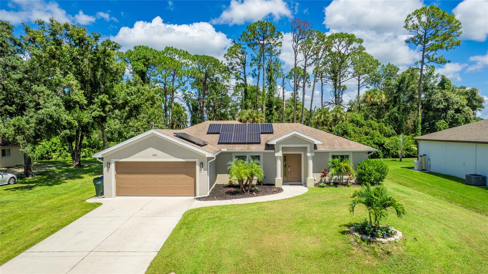 MODERN AND BUILT FOR EFFICIENCY. Built in 2018, after Florida’s stringent statewide hurricane building standards took effect in 2017, this contemporary 1,465 sq. ft., 3-bedroom, 2-bathroom home is the epitome of financially efficient Florida living. Located in the heart of North Port, it offers incredible monthly savings with no HOA or CDD fees and septic and well systems that eliminate water and sewer bills. A solar system (agreement to be assumed by buyer) reduces monthly electric bills, maximizing your savings. Inside, vaulted ceilings and premium laminate flooring create an open, elegant space perfect for entertaining. The stylish kitchen features stainless steel appliances, soft-close cabinetry, a stylish tile backsplash, under-cabinet lighting for a warm ambiance, and a reverse osmosis system in the kitchen for pure cooking and drinking water. Relax in the luxurious master suite that boasts a tray ceiling, two large walk-in closets, and a contemporary bathroom with a spacious walk-in shower. The second bedroom features an on-trend custom accent wall, adding a uniquely chic touch. Recent upgrades, include a 2024 water heater, water softener and peroxide system, ensuring low maintenance. Impact glass windows provide sound insulation and enhanced hurricane protection, paired with an ADT home security system for peace of mind. The spacious pool area is a true oasis, offering a saltwater pool with multi-color LED lights, a relaxing spa, a tanning shelf for lounging, and in-ceiling Bluetooth speakers. The garage was revamped with custom flooring for a polished look. Professionally maintained landscaping in the sizable yard with an irrigation system provides an opulent setting and robust curb appeal. Just 2 miles from shopping and I-75, this move-in-ready gem offers quick access to Sarasota, airports, and more, making it a rare find for cost-conscious buyers seeking quality and modern comfort.