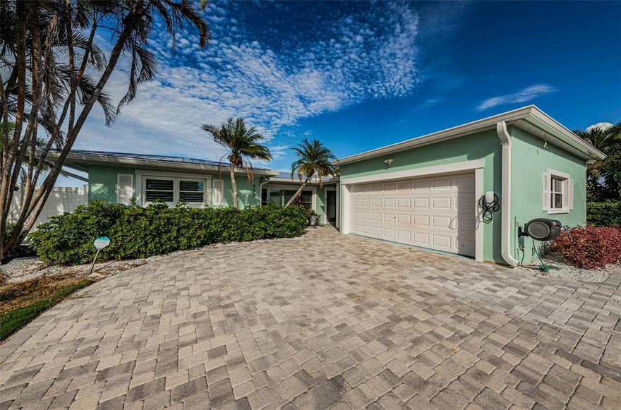LOCATED ON DAZZLING OPEN, INTRACOASTAL WATER, THIS BEAUTIFULLY UPDATED 4 BEDROOM, 3 BATH RESIDENCE OFFERS EXCEPTIONAL LUXURY LIVING SPACES – INSIDE AND OUT! A fine paver driveway introduces a home with lush scallop-edged travertine marble floors, graceful wood treatments and superb attention to detail. A unique breezeway with inviting covered entry opens to an attractive foyer with beaded-board wainscoting and gorgeous views of the waterfront. The large, open-concept multi-purpose dining area transitions to a wide waterfront living room with tumbled stone wall, entertainment center and built-in modern fireplace. A lovely designer kitchen boasts exquisite granite surfaces, tumbled marble backsplash, extensive cabinetry storage, quality stainless steel appliances and a custom breakfast bar. Retreat to the pampering owner’s suite with its large, beautiful bedroom overlooking the waterfront, and plentiful closet space with posh closet systems. Owner’s bath is a sumptuous coastal contemporary experience, with striking quartz surfaces, coastal white cabinetry, $5000 Neorest multi-function Toto toilet (one in each bath), custom shiplap wall finishes and a spacious walk-in rainshower with body sprays. All bedrooms are oversized and all baths enjoy elegant, lavish appointments. 4th bedroom makes for an ideal office or den. Indoor laundry provides generous storage. Step out back and discover a magical waterfront oasis. A splendid paver deck encircles your alluring Pebbletec pool and spa with open water views as your natural backdrop. The terrific built-in outdoor kitchen, richly adorned in granite and tumbled marble, features stainless steel gas cooking, a SS gas gridle, SS refrigerator, sink, and a bar area that seats 4. Impressive list of updates and improvements includes a new brick paver pool deck, new Pebbletec swimming pool/spa, new Jandy fully-automated and remote controllable pool equipment, newer A/C, newer composite dock, newer 5,000 lb boat lift platform, updated seawall, newer metal roof, new gutters, new epoxy garage floor, new built-in outdoor kitchen and bar area with gas cooking, Tesla electric vehicle charger, plantation shutters and so much more! Invite you to compare, this is a tremendous value for a large updated home on the intracoastal waterway. Measurements are estimates, buyer to verify.