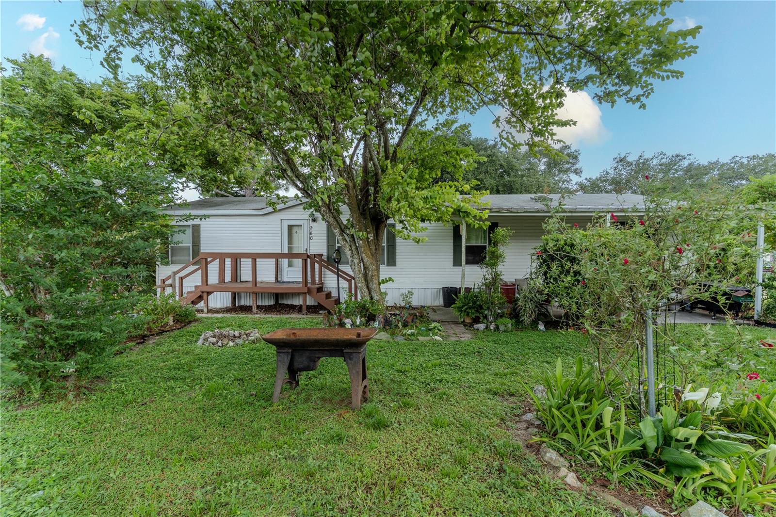 **NEW A/C** Welcome to this charming three-bedroom, two-bath double-wide mobile home, nestled on nearly half an acre of serene land. This inviting property offers a splendid opportunity for those looking to create their own space, blending comfort with the joys of nature. As you step inside, you’ll find a spacious living area featuring vaulted ceilings that add a touch of openness to the room. The thoughtful split-bedroom plan provides privacy for everyone, making it perfect for families or guests. The large kitchen, complete with an island and breakfast bar, is an inviting spot for morning coffee or casual meals. An indoor laundry area adds convenience to your daily routine, ensuring that chores are a breeze. The primary suite is a welcoming retreat, boasting an en suite bathroom complete with stand up shower and garden tub, perfect for unwinding after a long day. This home comes equipped with several valuable updates, including a new air conditioner and water heater, as well as an updated electrical panel, providing peace of mind and efficiency for years to come. Outside, the expansive lot is adorned with mature vegetation, providing a sense of tranquility and privacy. Enjoy your morning cup of coffee or evening sunset on the covered front porch, a lovely space to relax and take in your surroundings. Additionally, a climate-controlled storage shed offers extra space for your tools, hobbies, or seasonal items, making organization simple. This property presents a wonderful opportunity to embrace a comfortable lifestyle in a peaceful setting. Don’t miss the chance to make this home your own! Schedule a showing today!