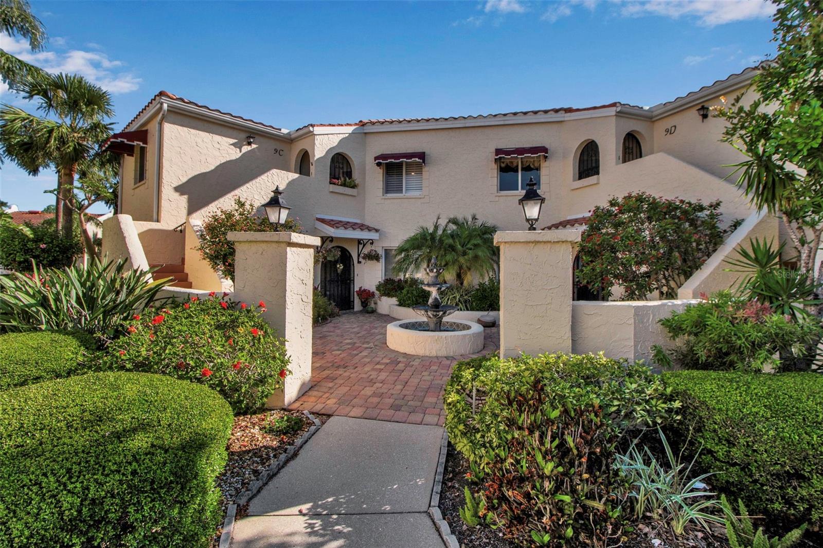 VIZCAYA! You know even the name takes your imagination away! This exceptional 3/2 Lakefront beauty is truly a cut above the norm...includes brand New $11,000 A/C installed 5/27/25 and even showcases designer furnishings which will be included with acceptable offer! This gem has not only one large lake vista but also nestled with views of a second! Charming, "Old World" Mediterranean architecture with its entry courtyard and tiered fountain will catch your artistic eye. A custom wrought iron gate invites you through the alcove into this gorgeous, immaculate piazza! Beautiful tropical visions from the lake the moment you walk in the door. Immediately you'll feel the comfortable living you have been seeking due to its' expansive wide floorplan designed more like a single-family home than a typical linear condo. Choice eastern exposure off the lake plays to the casual elegance of the interiors enhanced by the natural light and the desirable vaulted ceiling along with pristine, luxury carpet. The Great Room flows out to the big tiled and glassed Florida room - beckoning for relaxation. The stylish, upgraded kitchen is open and airy...granite counters, ease of sliding pull out drawers and with a breakfast table area looking down through planation shutters to the front courtyard with peaceful fountain sounds. Private guest quarters and versatile third bedroom/den with closets have their own indoor/outdoor appeal with a terraced balcony. Attractively updated second bath. The primary bedroom, graciously sized with a vaulted ceiling and views out to the lake, features large walk-in closet and a delightfully upgraded en-suite bath with double vanities, customized mirrors and lightening, soaking tub and Roman walk-in shower. In addition to being able to keep your doors open almost year round to catch cool, cross breezes from the second floor, you get the incalculable value of not having the pitter-patter of anyone above you. (Remember that first floor units do not have the advantage of the high ceilings, breezes and privacy as mentioned - it does matter!.) Vizcaya is known for its outstanding Clubhouse and Olympic sized geothermally heated pool with additional amenities such as exercise room & sauna. Along with all of the conveniences of nearby shopping, approximately 8 miles to the renowned Gulf beaches and close proximity to downtown Sarasota with its cultural activities. Includes carport, is pet friendly, and has the added appeal of being a gated community.