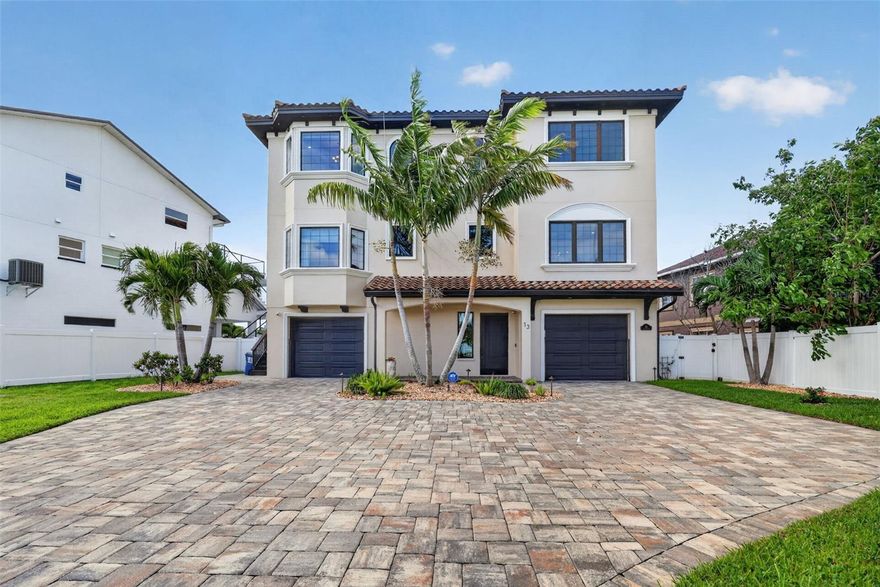 One or more photo(s) has been virtually staged. Magnificent, luxurious waterfront coastal home on Paradise Island, right off the intercoastal on Boca Ciega Bay. Designed by renowned architect Scott Hines and completed in May 2019, this gorgeous home has four full en-suite bedrooms and three covered balconies overlooking a scenic, dolphin-filled bay, complete with a dock that extends 40 ft into the water and a heavy-duty, high-speed 13,000-pound Neptune boatlift. Boat to the Gulf for awe-inspiring sunsets in minutes or walk five blocks to the white sand beaches of Treasure Island for swimming, sunbathing, and drinks on the beach (The Jeanneau French-made boat is available for purchase). The home’s ground level includes a huge 4- to 5-car garage with an electric-car charging port and plenty of space for tools, art projects, or table tennis. Nights are lit by high-end landscape yard lights and LED multicolor in the heated Pebble Tec saltwater pool and hot tub. Grill the fish you catch on your dock in a high-end outdoor kitchen, equipped with a FireMagic oversized grill and refrigerator, plus a sink, and a granite countertop. Watch sports or movies from the hot tub or the kitchen table on the high-end Samsung Terrace-brand TV. Take the stairs or elevator to the second level, where you will step into an open-concept space with a superb Chef's Kitchen to the right that features custom solid hardwood cabinetry, designer luxury countertops, Kitchen-Aid appliances, 2 Islands and a Wine/Beverage Center, including an Ice Maker, two dishwashers, and a butler’s pantry, that completes the masterpiece kitchen. To the left, set up your family space for watching TV or for a panoramic view of the water through the 4 glass sliding doors leading to your luxurious covered patio. The level includes a breakfast area off the kitchen, and a bonus room that may be a formal dining room or an office. A half bath is in this space. One en-suite bedroom with a beautiful water view of Boca Ciega Bay completes the second level. Take the elevator or stairs up to the third floor to find three more en-suite bedrooms, all with amazing water views. One is complemented by floor-to-ceiling cabinets and shelves, making it an excellent work-from-home office. Two of the bedrooms open to a large, covered patio with engaging water views. And in the middle of the floor, enjoy a large bonus room for a “man’s cave” or crafts room, that also opens to the balcony. Enjoy privacy with the high-end custom Hunter Douglas drapes/blinds. The majestic master suite boasts stunning water views from both sides, separate his/her closets, and an exquisite master bath with a spacious custom shower and an elegant soaking tub. Enjoy natural stone, hardwood, and Italian porcelain flooring, designer fixtures, and spectacular architectural appointments throughout your new home. The home is freshly painted inside and outside. The property is protected from flooding by new state-of-the-art flood panels and a new seawall. The house has a whole-home water filtration system and a drinking water filter in the kitchen. Come visit this exceptional waterfront home with its modern design and breathtaking views, elegant finishes, and supreme outdoor living spaces! Walk out on your dock and look up at the planets and be kissed by the bright stars at night. Imagine swimming with the dolphins off your private dock and paddleboarding from cove to cove. You’ll soon be living in paradise, on Paradise Island, just off the coast of St. Petersburg, Florida.
