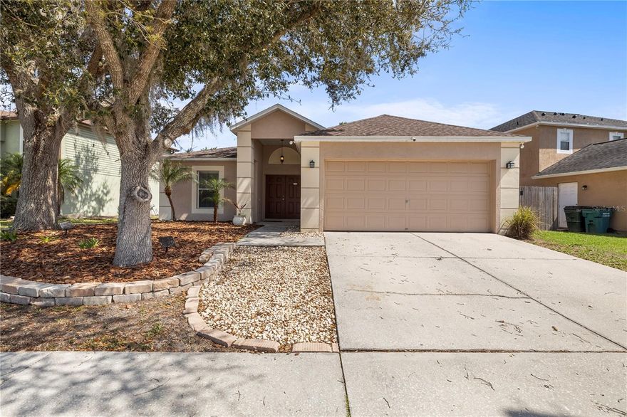 Welcome to this well-designed 3 bedroom, 2 bathroom home located in the heart of Land O Lakes/ Wesley Chapel, offering comfort, functionality, and a layout perfect for everyday living. As you enter, you’re greeted by a spacious family room that creates a warm and inviting first impression, seamlessly connecting to the kitchen through an elegant arched doorway. The kitchen offers ample cabinet space, a large pantry, and a cozy dinette area ideal for casual meals, with convenient access to the garage just off the dinette. The kitchen also flows into a separate dining room featuring sliding glass doors that lead to the backyard, allowing for great natural light and easy indoor-outdoor living. On the left side of the home, two secondary bedrooms are connected by another arched hallway and share a full bathroom with a shower-tub combination. The private primary suite is tucked away on the opposite side, featuring an en suite bathroom with dual sinks, a walk-in shower, a large garden soaking tub, and a spacious walk-in closet with plenty of storage. Step outside to a fully fenced backyard with a wood privacy fence, offering a peaceful and private setting, along with a slab patio that serves as the perfect foundation for a future lanai. Conveniently located near top-rated shopping, dining, and the Tampa Premium Outlets, this home combines location, layout, and lifestyle all in one.