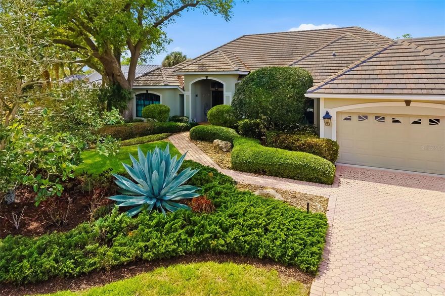 Welcome to the prestigious Calusa Lakes Golf Club community, where timeless elegance meets the relaxed Florida lifestyle. Ideally on a quiet cul-de-sac in the sought-after Enclave at Calusa Lakes, this exceptional three-bedroom, three-bath residence offers 3,000-plus square feet of beautifully designed living space, a three-car garage, and a spectacular private preserve and waterfront setting. From the moment you arrive, you’ll be captivated by the paver driveway and walkway, lush tropical landscaping, barrel tile roof and grand double-entry doors. Inside, soaring 12-foot ceilings, exquisite chandeliers, and tile flooring throughout the main living areas create an atmosphere of sophistication and warmth. The thoughtfully designed floor plan features formal living and dining rooms, a spacious family room, a dedicated office with rich cherry wood flooring, and two stunning aquarium windows that flood the home with natural light while framing breathtaking views of the tropical backyard oasis. The chef’s kitchen is elegant and functional, offering white cabinetry, granite countertops, a dramatic curved island with seating for four, a natural gas cooktop, built-in JennAir wall oven and microwave, and a separate breakfast area with an aquarium window overlooking the pool. The luxurious primary suite is a retreat, complete with private access to the lanai, two generous walk-in closets, a cozy reading alcove and a mini-split air-conditioning system for customized comfort. The spa-inspired primary bath features dual vanities, a soaking tub, a large Roman walk-in shower and a private water closet. Two additional guest bedrooms provide privacy and comfort, each with carpet, crown molding and access to beautifully appointed full baths. One guest suite serves as an en suite and convenient pool bath. Go outside to a resort-style outdoor living space designed for entertaining and relaxation. The expansive paver lanai offers multiple covered seating areas, an awning, a built-in summer kitchen, a sparkling heated pool and spa, and tranquil views of the tropical landscape and water beyond. The lush backyard provides exceptional privacy and ample green space beneath mature trees and tropical landscaping. Additional features include central vacuum, generator, laundry room with sink and granite counters, extensive garage cabinetry and storage, utility sink and a newer roof. The home may be purchased semi furnished with an acceptable offer, or select furnishings may be available under a separate bill of sale. Residents of Calusa Lakes enjoy a gated lifestyle with access to golf, tennis, pickleball and a clubhouse, all just minutes from Sarasota Memorial Hospital - Venice, world-renowned beaches, charming downtown Venice, and all the cultural and recreational amenities of Florida’s Gulf Coast. This is more than a home, it is a private sanctuary where luxury, comfort and natural beauty come together in one extraordinary setting.