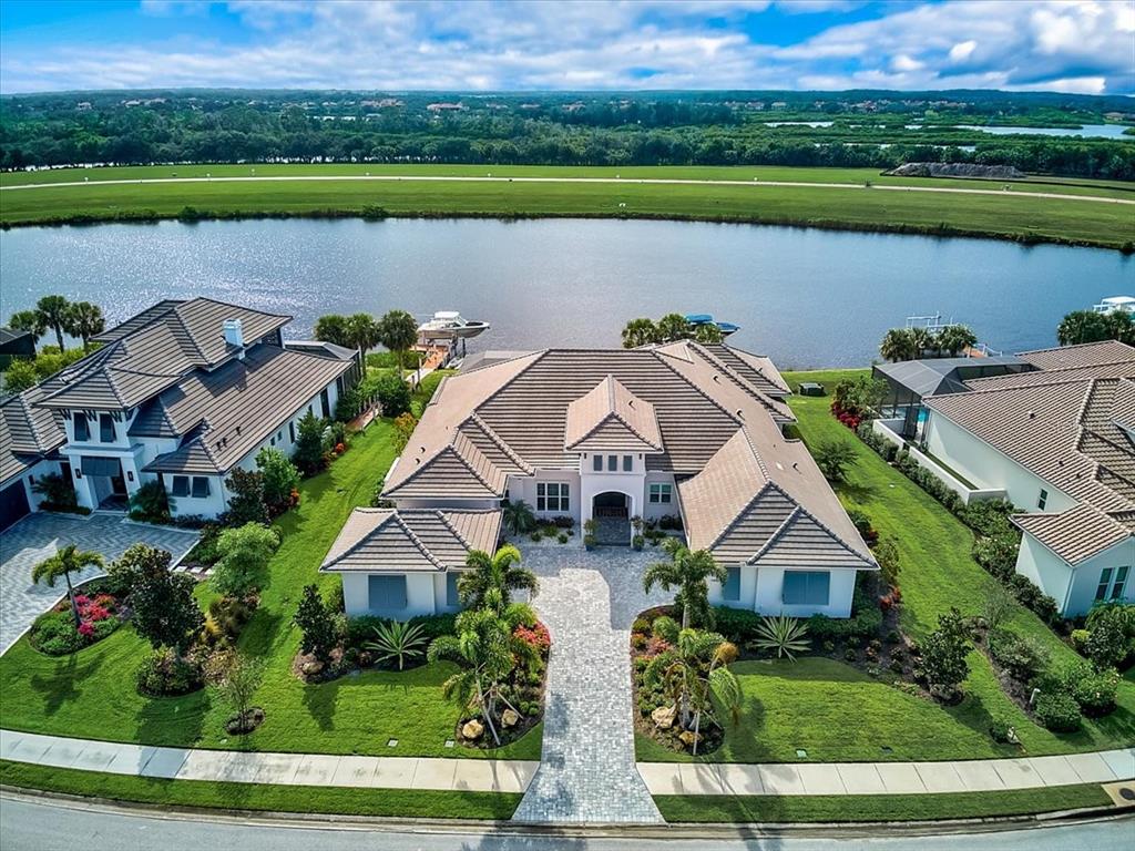 Taking back-up contract. This is a stunning West Indies style waterfront home in gated Islands on The Manatee River. This lot is located at the canals widest spot for deep water views and additional privacy. This property has location with easy water access to the Gulf of Mexico, Interstate 75, and all daily living needs. The Islands were created along the Manatee River with ground level for house above the flood zone. The separately gated Harbourside Lane only has 1 bridge with a 14 foot clearance to the newly created river access. This luxury property has been custom designed and built by Arthur Rutenberg with an ultimate attention to details. From the minute you open the front door and look across the great room featuring soaring tongue and groove ceilings with beams, bountiful moldings, gas fireplace, and well-thought-out built-in designs onto the water you feel the quality invested in this home. Every detail of the kitchen is custom from it design, location, and high-end appliances. Dining overlooking the water is an intimate experience. The 4000 square feet of AC living space was maximized and extended to the outdoor living space through disappearing corner glass pocket sliding doors. Both are spaces equally essential to living in this Smart System property. The full outside kitchen has a gas grill, sink, and full-size refrigerator. The saltwater pool and spa with a sun ledge and water accents is alluring. Impact windows and doors, sprayed foam attic insulation, pool solar heat & saltwater system, and gas generator are some of the green featured items in this property. The master bedroom retreat features an owner’s private den, steam shower, private garden with water fountain, wonderful walk-in closet built-ins, and cosmetic center with natural light. All this and still looking out to the beautiful pool and waterviews. This house was designed with family and grandkids as an integral part of the owner’s world. The 2 kayak lifts and boat dock are essential to the Florida living experiences. There is only one community bridge to the new Manatee River access. The river flows into Downtown Bradenton and onto the Gulf of Mexico. The River Wilderness communities has a membership optional Country Club with 18 hole golf course, but the Islands On The Manatee River is the jewel of this development. With 178 homesite, there are 23 remaining for sale. This custom home shows new; and allows the new owner the ability to bypass the required build-out process. There are many more details to appreciate in this complete and amazing property. Room sizes are estimated. Agents please see the Realtor Only Remarks. Room Feature: Linen Closet In Bath (Bedroom 2). Room Feature: Linen Closet In Bath (Primary Bathroom).