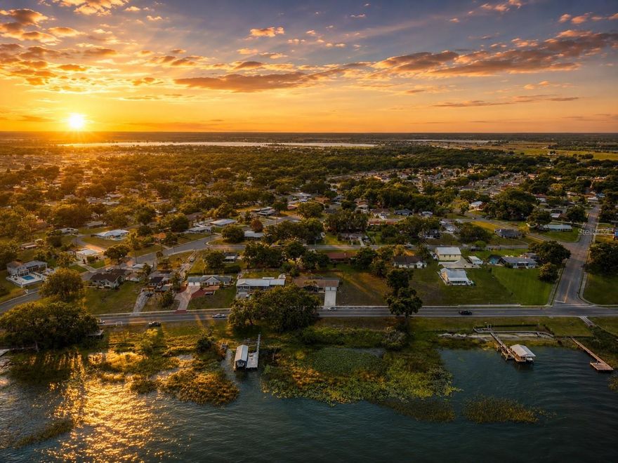 STOP SCROLLING… because homes like this don’t come around often. Welcome to 1316 Lake Ariana Blvd, Auburndale, FL where everyday living feels like a peaceful lakeside retreat. Perfectly positioned directly across from beautiful Lake Ariana, this spacious 3-bedroom, 2.5-bath home captures stunning water views from nearly the entire front of the home and delivers the kind of Florida lifestyle people dream about.And one of the rarest features of all? This property includes an additional lot directly across the street on the lake side, giving you the opportunity to create your own private waterfront experience. Build a dock, boat lift, launch area, lakeside hangout, or simply enjoy owning your own piece of Lake Ariana frontage a feature that is incredibly hard to find and adds tremendous long-term value and lifestyle appeal.From the moment you walk in, you’re greeted by soaring vaulted ceilings with exposed beams, a gorgeous stone fireplace with custom decorative shelving, upgraded lighting, and oversized windows that bring in warm natural light and breathtaking sunset views over the lake. The massive kitchen is truly the heart of the home — featuring granite countertops throughout the wet areas, abundant prep space, and an ideal layout for entertaining, gathering, or hosting holidays with ease.The thoughtfully designed floor plan offers spacious bedrooms, a private formal dining room with a stylish barn door entrance, luxury vinyl plank flooring throughout the main living areas, an oversized indoor laundry room, and an expansive garage complete with additional storage space.Step outside to your oversized back lanai the perfect setting for summer BBQs, entertaining guests, creating your dream outdoor kitchen, or even designing a future pool oasis. Every inch of this property feels clean, inviting, and move-in ready.Located in the heart of Auburndale, Lake Ariana is known for boating, fishing, water skiing, and stunning Central Florida sunsets. Residents enjoy easy access to waterfront recreation while still being conveniently located between Tampa and Orlando. Whether you’re searching for a full-time residence, a Florida vacation home, an upsized lifestyle, or even exploring short-term rental possibilities, this property offers versatility, views, and an unbeatable lake lifestyle.This isn’t just a home…It’s lake life, golden sunsets, peaceful mornings, and the kind of atmosphere people remember long after they leave.