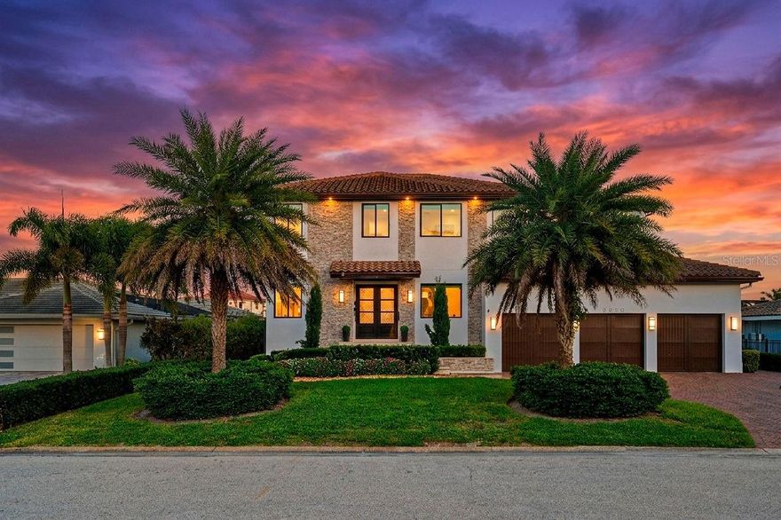 A spectacular custom waterfront estate with a clean California Modern design, this exceptional home stands out in one of St. Petersburg’s most sought-after neighborhoods. Built with an impressive level of detail and craftsmanship, it offers a rare combination of style, comfort, and functionality. Don't miss the video 1172020405 walk-thru at Vimeo. The front exterior makes a strong first impression with extensive stonework, a marble walkway, and custom composite wood Eden Coast 3-car garage doors. Inside, the open-concept layout is enhanced by 8-inch wide French oak flooring throughout and airy 10-foot ceilings. Just beyond the home office with custom built-ins, architectural columns with modern stone accents add character and definition to the main living space. The kitchen is thoughtfully designed with Cambria Britannica countertops, KitchenCraft cabinetry, Thermador appliances, and matte black finishes. An oversized walk-in pantry and butler’s pantry with a sink and wine refrigerator provide excellent prep and storage space. The large one-piece quartz island seats five comfortably, with additional room for dining in the breakfast area. The great room features wood ceiling beams, a striking stone accent wall, and built-in cabinetry with custom wood paneling that continues into the dining room ceiling, creating a cohesive and polished look. The first-floor primary suite offers water views and a private bath entered through custom barn doors. The bathroom includes floor-to-ceiling marble tile, a soaking tub, a large walk-in shower, and matte black fixtures. The spacious 16.5' x 7' walk-in closet is paired with a private laundry room in the suite, and there is an additional laundry room upstairs. Motorized blinds add everyday convenience throughout the home. Upstairs, the custom oak staircase with open risers, iron railing, and statement chandelier leads to a large loft area. Through the 8-foot sliders, the balcony offers beautiful Tampa Bay views along with marble flooring and wood-beamed ceilings. The second level also includes four oversized bedrooms with French oak flooring and three full bathrooms finished with marble floors, designer tile, and quartz countertops. The outdoor living area is equally well designed. Hurricane-rated 8-foot sliding doors open to a covered outdoor kitchen with custom granite counters, weatherproof cabinetry, a 38-inch stainless Delta Heat grill with hood, and a beverage center with sink. The backyard is set up for year-round enjoyment with a gas-heated pool and spa, tumbled marble decking, and a seating area centered around a fire table activated at the push of a button. For boating, the property offers custom dockage and a high-speed lift capable of handling a vessel up to 24,000 pounds, with access to sailboat water. The Synlawn artificial turf backyard includes a putting green and offers a low-maintenance alternative to natural grass. Additional features include a Sonos sound system and generator-ready wiring. Homes with this level of finish and attention to detail rarely become available. This is a unique opportunity to own a custom waterfront residence in a premier St. Petersburg location. Photography, renderings, floor plans, descriptions, current furnishings, dimensions, square footage, and features are approximate, for illustrative purposes only, and subject to change without notice. Buyer to verify all information through personal inspection. Equal Housing Opportunity.