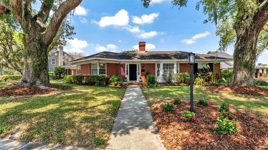 This traditional brick home sits in an established Lakeland neighborhood, surrounded by mature landscaping and a classic brick exterior that gives it a timeless feel. A front porch and walkway create a welcoming entry as you arrive. Inside, the layout is both comfortable and functional. The foyer leads to a spacious dining room with wood-paneled walls, while the family room features vaulted ceilings, built-in cabinetry, and French doors that connect easily to the rest of the home. The living room has a relaxed feel with a gas fireplace, built-in shelving, and a bay window that brings in light and adds character. The kitchen is practical and easy to work in, with plenty of cabinet space, stainless steel appliances, and a casual eat-in area with additional built-ins.

Just off the kitchen, a standout feature of the home is a private granny flat/multigenerational space. This area includes its own living and sleeping space, walk-in closet, and an updated bathroom with a tiled walk-in shower—ideal for guests, extended family, or a private office setup.

The primary bedroom includes hardwood flooring, a large closet with built-in storage, and an en-suite bathroom with classic tilework, a tub and shower combination, and extra storage. Three additional bedrooms are well-sized, one with built-in desks and cabinetry, making it a great option for an office or study. There’s also a full bathroom and a half bath for added convenience.

For added flexibility, the home includes one laundry area inside, along with an additional laundry setup in the garage—making everyday tasks more convenient, especially for larger households or multi-generational living.

Outside, the property features a long driveway for ample parking and a private patio area with a fire pit, surrounded by mature trees and greenery—perfect for relaxing or spending time outdoors. Located just one block from Lake Hollingsworth and only minutes to Lakeland Country Club and downtown Lakeland, you’re close to some of the area’s most desirable spots for recreation, dining, and everyday living. This is a one-of-a-kind home you don’t want to miss—schedule your showing today.