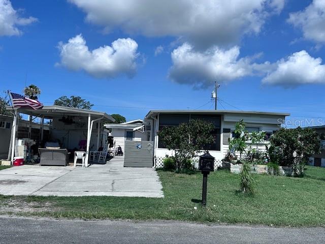 All ages welcome. Own your own land. Low HOA (includes trash 2 week) - Low Taxes! Mobile home with an exterior concrete wall. Measurements are: 20'25" x 48'50". Live and play on every part of this fenced property with a palm tree, banana tree with a mature landscape. This 2/2 with a carport has been improved with a sealed metal roof, freshly painted, 2024 Samsung stainless steel kitchen appliances, faucet and fans. Septic tank has recently been pumped. Walk through the new security gated screen door on the front porch with a keyless touchpad into the living room with slider doors. Enjoy a clean look with all new window blinds throughout the home. Property inside and out has been pest control treated. Enjoy a bright kitchen which overlooks the front yard and a large dining area with a fan / light kit, mirror and shelf on the wall. The living room has 2 built-in bookshelves to hold your prized possessions, an electric fireplace and a brand new GE heating/cooling 115v / 8000 BTU Smart Control unit with WiFi capability and a 1 year warranty. One bedroom has a closet and built-in dresser while the other large enormous bedroom has a concrete wall and exterior door into the back fenced yard. One bathroom has a double sink and shower tub. Enjoy an inside laundry room with a shower, toilet and small workbench with power. Make memorable nights on concrete covered ground under the carport with 3 ceiling fans. A concrete building holds shelves, electricity and workbenches. The back yard with beautiful green grass is secured by 2 side fences and a raised vegetable garden. Enjoy shopping, restaurants, Gulf of Mexico, Suncoast Parkway, nearby MacDill AFB, hospitals, new VA Outpatient hospital, forthcoming H. Lee Moffitt Cancer Center and Research Institute will have a world-class expansion campus in Pasco County within a few years, beaches, and MORE at your fingertips! Tampa and St Pete Clearwater Airports are 30+ minutes away! Play anywhere in central Florida! Our playground awaits you !!