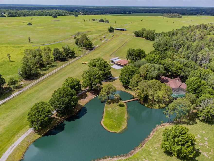 This 34 acre (MOL), 2 home property isn't just a place to live; it embodies a whole lifestyle. It presents a rare opportunity for aviation enthusiasts, equestrians, and nature lovers to immerse themselves in a world defined by its natural beauty, tranquility, and protected surroundings. Situated on approximately 34 acres, the property is surrounded by expansive ranches and farms, ensuring a serene and development restricted atmosphere per a Florida land agreement. With a total of 2 Residences, the main home is a 3/3, 3728 sf rustic lodge-style ranch, with a PRIVATE RUNWAY and HANGAR, and features impressive cathedral ceilings, a cozy wood-burning fireplace, and large windows that offer picturesque views of the lush landscapes and a peaceful pond. Every aspect of this property exudes comfort, privacy, and a connection to nature.  A second 2/1,1600 sf residence offers a great opportunity for guests, tenants, caretakers, or other family members to enjoy this perfect location. Guest house has been renovated which also includes a new roof and A/C. Notable highlights include your very own private airport with a 2,600 x 150-foot engineered grass runway (BURNTWOOD RANCH/FL43), a private hangar, enclosed observation deck, a pole barn with electric and water, and much more. The property's strategic location offers the tranquility of a rural retreat while remaining conveniently close to major metropolitan areas, international airports, and recreational activities. Updates include a NEW POOL CAGE, NEW INTERIOR PAINT, NEW Bamboo trees planted along the private entrance, and more! This is a unique opportunity to own a piece of paradise, complete with a charming lodge surrounded by untouched landscapes and a second home for guests or rental purposes. Whether you're seeking a getaway, a place for your animals, or a permanent residence without the restrictions of an HOA or aviation community runway, this property promises an exceptional private experience. The property is uniquely positioned, providing the privacy and tranquility of a rural retreat while remaining conveniently close to major metropolitan areas, international airports (Orlando & Tampa), restaurants, shopping, universities, and major interstates. Schedule a private tour today to discover this rare gem!