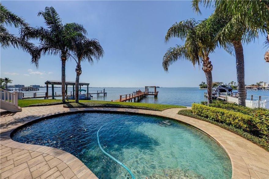 If spectacular sunsets and a panorama view of Honeymoon Island to the west and Caladesi Causeway to the south are what you are looking for, then this casually elegant 4 bedroom, 3 bath homes is for you. A quiet dead-end street in Ozona makes the location a perfect private oasis to enjoy all that Gulf of Mexico waterfront has to offer. Ozona is a boating community with boats of every description and size. This tucked away area is unique and offers fun filled options for paddleboarding and kayaking on the quiet waters in the morning, and waterskiing, Jet skiing, and boating throughout the day. Honeymoon Island beaches are just moments away by boat. The new dock was built in 2019 and has water and extra electrical outlets. The boat lift is set up for two jet skis but can be easily reconfigured for your boat. There
are always cool breezes off the Gulf to enjoy as you swim in the beautiful Pebble Tec saltwater pool in
the summer and enjoy the winter months as well, as the pool is heated by a new Pentair heat pump.
You will never miss a breathtaking sunset from your patio and covered lanai or stargaze from your open balcony off the upstairs master suite. There is lots of fenced yard space, decorative lighting, lush landscaping, and 90+ ft. of waterfront. This home has been lovingly and extensively renovated throughout. From the time you enter, you will love the easy to maintain rustic travertine tile flooring in the main part of the house and the beautiful hardwoods in the bedrooms. Crown molding and lots of
wood trim add to the ambiance of the home and a cozy gas fireplace will set the tone for enjoying life with family and entertaining friends. A huge island is the heart of the kitchen with abundant custom wood cabinetry and counter space. All Stainless GE Profile appliances are a joy to use. Off the kitchen is an office space with cabinets and room for storage. The kitchen and all bathroom cabinets in the home have stunning granite countertops. The separate dining room features a beautifully crafted tray celling and skylight. The master suite is situated on the second floor, with 2 large closets, a spacious bathroom with two sinks and a walk-in shower. It has a large balcony facing west and overlooking the pool. The home has new impact windows and impact sliding glass doors. The huge garage is approximately 20x40. The roof was new in 2015 and is still under warranty, which is transferrable. New soffits, facia boards, and an oversized gutter system were installed in 2021. Train high efficiency heat pump/air conditioners with Halo air purifiers were installed in 2019 and 2023. Ozona Is a golfcart friendly unique community with many restaurants, shops, 6 marinas, its own post office, and ice cream parlor. You can walk to the Pinellas Trail and are close to top-rated schools, including Ozona Elementary, Palm Harbor Middle, and Palm Harbor University High School. Enjoy the unparalleled casual charm and beauty of this one-of-a-kind property. This is Florida living at its best!