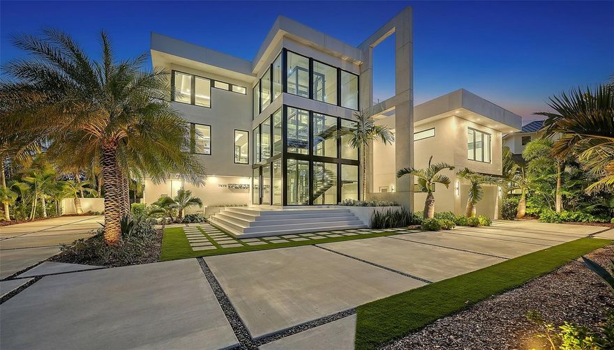 Stunning waterfront three story, coastal modern, single-family waterfront home is the perfect blend of comfort and luxury located in the treasured Cherokee Park neighborhood. Nestled on a street adorned with majestic oak and canopy trees, this exceptional property offers both privacy and grandeur. As you approach this generous lot, you'll be greeted by an electric gate entryway. Choose to park in either the detached two-car garage beneath the guest house or the hidden 6-8 car garage on the side of the house. The garage level features a private gym with a bathroom and an extraordinary outdoor living space that includes both covered and uncovered areas, a stainless steel outdoor kitchen, and a fire pit. Entering the home, you're captivated by a glass box foyer entryway with a custom staircase and state of the art glass elevator. There is also an entryway through the 6+ car garage leading to the elevator. The spacious second-floor living area boasts an open floor plan perfect for any event. The elegant great room features a custom glass floor and firebox, leading to a beautiful open kitchen with custom cabinets, waterfall stone countertops, and Subzero and Wolf appliances. Adjacent to the kitchen is a bonus room and an open yet private dining room, ideal for a wine collector with its floor-to-ceiling glass wine cellar that doubles as an art piece. Behind the kitchen cabinetry, you'll find a separate sizable pantry and laundry room. This floor also features a beautiful balcony accompanied by a glistening hot-tub/dipping pool that waterfalls into your main pool. Make your way to the third story to find 4 on suite bedrooms and a second laundry room. The primary bedroom offers an expansive layout that seamlessly blends comfort and elegance. The true highlight is the gorgeous balcony overlooking the pool that leads to a staircase up to the breathtaking rooftop. From here, you will enjoy panoramic views of the spectacular Sarasota. Whether you’re hosting a sunset soiree or savoring peaceful morning coffee, this rooftop oasis provides an extraordinary vantage point. This seamless indoor-outdoor flow and the captivating scenery make this property a true gem for those seeking both luxury and tranquility in a prime location.