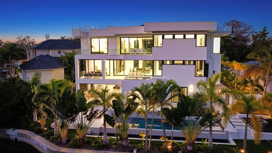 Stunning waterfront three story, coastal modern, single-family waterfront home is the perfect blend of comfort and luxury located in the treasured Cherokee Park neighborhood. Nestled on a street adorned with majestic oak and canopy trees, this exceptional property offers both privacy and grandeur. As you approach this generous lot, you'll be greeted by an electric gate entryway. Choose to park in either the detached two-car garage beneath the guest house or the hidden 6-8 car garage on the side of the house. The garage level features a private gym with a bathroom and an extraordinary outdoor living space that includes both covered and uncovered areas, a stainless steel outdoor kitchen, and a fire pit. Entering the home, you're captivated by a glass box foyer entryway with a custom staircase and state of the art glass elevator. There is also an entryway through the 6+ car garage leading to the elevator. The spacious second-floor living area boasts an open floor plan perfect for any event. The elegant great room features a custom glass floor and firebox, leading to a beautiful open kitchen with custom cabinets, waterfall stone countertops, and Subzero and Wolf appliances. Adjacent to the kitchen is a bonus room and an open yet private dining room, ideal for a wine collector with its floor-to-ceiling glass wine cellar that doubles as an art piece. Behind the kitchen cabinetry, you'll find a separate sizable pantry and laundry room. This floor also features a beautiful balcony accompanied by a glistening hot-tub/dipping pool that waterfalls into your main pool. Make your way to the third story to find 4 on suite bedrooms and a second laundry room. The primary bedroom offers an expansive layout that seamlessly blends comfort and elegance. The true highlight is the gorgeous balcony overlooking the pool that leads to a staircase up to the breathtaking rooftop. From here, you will enjoy panoramic views of the spectacular Sarasota. Whether you’re hosting a sunset soiree or savoring peaceful morning coffee, this rooftop oasis provides an extraordinary vantage point. This seamless indoor-outdoor flow and the captivating scenery make this property a true gem for those seeking both luxury and tranquility in a prime location.