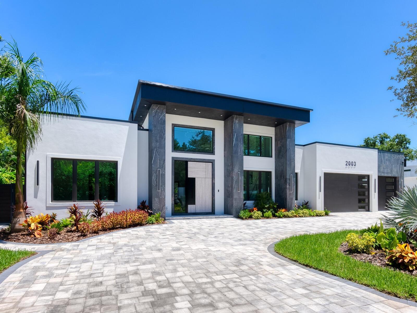 A Striking Modern Residence in Sarasota – Welcome to 2003 S Shade, where architectural design, modern elegance, and everyday luxury come together seamlessly. This custom-built, single-story home offers 4 bedrooms, 4.5 bathrooms, and a thoughtful floor plan designed for both grand entertaining and private relaxation.
The sleek chef’s kitchen features flat-panel custom cabinetry, an expansive center island, and integrated panels on the refrigerator and dishwasher to maintain a clean, cohesive aesthetic. The kitchen flows effortlessly into the open-concept living and dining areas, where high ceilings and oversized glass sliders create a bright, airy atmosphere.
The primary suite is a true retreat, boasting a spa-inspired bathroom, oversized shower, and dual custom walk-in closets. Each guest bedroom enjoys its own en-suite bath, ensuring comfort and privacy for all.
For car enthusiasts, the spacious 3-car garage pairs perfectly with a large, dual-entry driveway, allowing easy in-and-out access for multiple vehicles.
Outdoors, enjoy a sparkling pool with elevated spa, a built-in grill, and an outdoor wet bar—perfect for entertaining in style. The screened enclosure offers a comfortable and functional space to relax and host gatherings year-round.
Perfectly situated near Sarasota’s renowned beaches, shopping, dining, and cultural attractions, 2003 S Shade blends style, functionality, and location into one exceptional property.