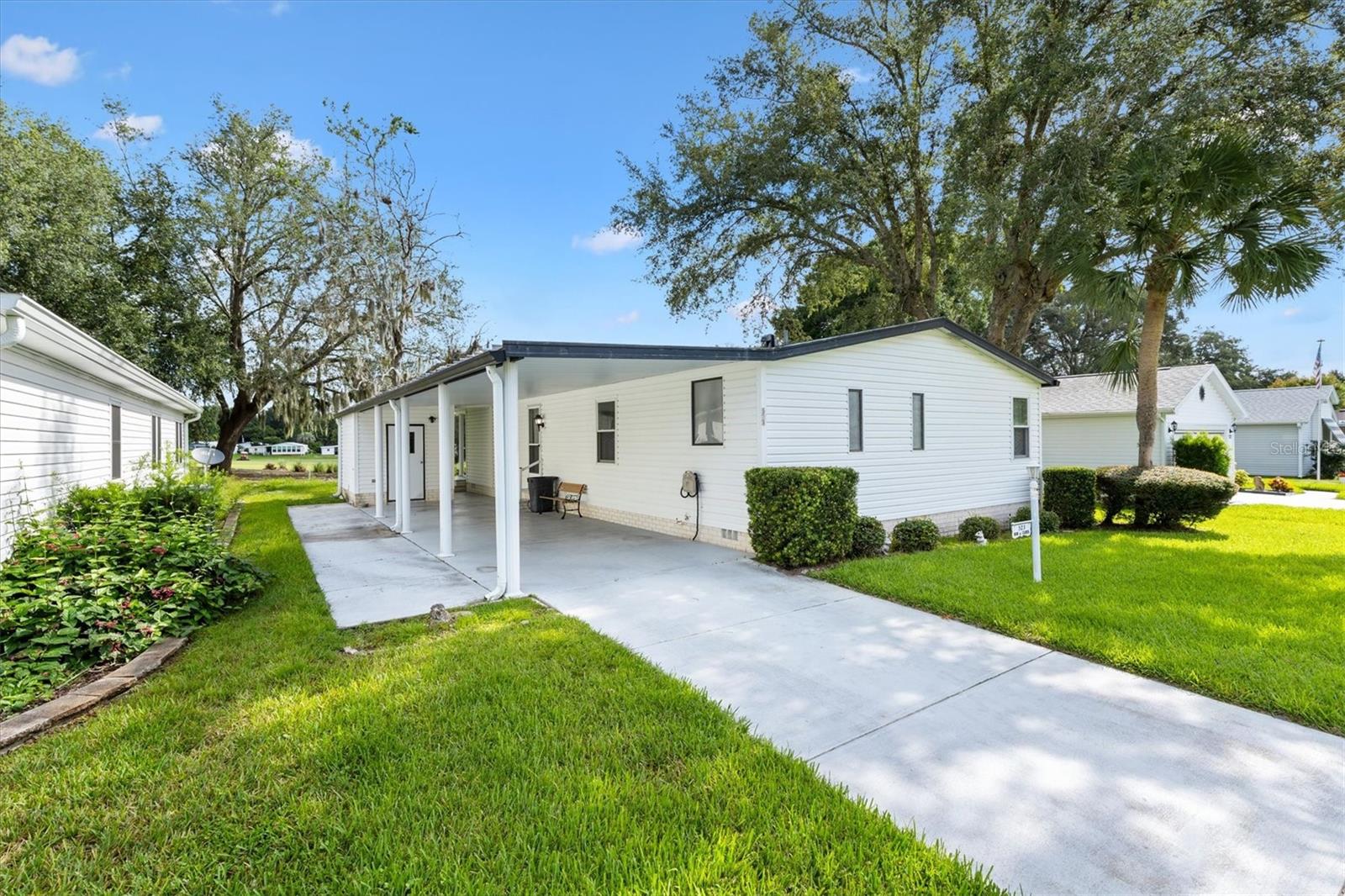 ON GOLF COURSE 2/2 Manufactured Home 4th Hole Silver Springs Golf Course. ROOF 2021 HVAC 2018 NO BOND! Stunning fairway views from the comfort of your living room. Enjoy natural light and picturesque scenery through the large windows or relax in the enclosed lanai accessed by sliding glass doors—perfect for year-round comfort. Step outside to the back outdoor patio, soak in the tranquil setting and watch the golfers. Inside, you'll find a spacious living and dining area featuring a built-in bar and cabinets, as well as an entry coat closet for added convenience. The eat-in kitchen is both functional and charming, with a pantry closet, built-in desk with extra storage, a skylight, and built in seating area. The primary suite features a walk-in closet and an updated ensuite bathroom with a glass-door shower, single vanity (with space to convert to dual), and an additional large closet. The guest bath with has a tub/shower combo with glass doors. Additional highlights include: Ceiling fans and blinds throughout, Partially furnished for easy move-in, Mirrored closets for added brightness. Utility room with washer, dryer, utility sink, and shelving. Whether you're looking for a seasonal escape or full-time residence, this home offers comfort, storage, and unbeatable golf course views. Just a short golf cart ride to the Silver Lake Community Pool and Hot Tub and less than 2 miles to Spanish Springs Town Square for entertainment, dining and shopping. This location can’t be beat. Make this home your own and start living the Villages dream. View our video and make your appointment to see this home today!