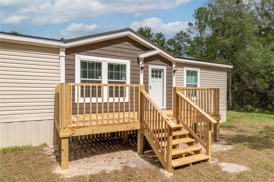 Freshly completed and never occupied, this pristine 2024 manufactured home is ready for its first owner! Fenced and gated on over 3 acres in the peaceful Island Lake Acres community, the property is offered fully furnished with brand-new furnishings throughout, perfect for a seamless move-in or immediate rental opportunity. The 3-bedroom, 2-bath split-bedroom layout offers 1,404 square feet of thoughtfully designed living space. Inside, you’ll find a bright open floor plan that features luxury vinyl flooring, lots of natural light, and modern finishes that combine comfort and style. The kitchen includes an eating nook and comes equipped with stainless steel appliances, a large center island with breakfast bar, and ample cabinet and counter space. A separate laundry area with washer and dryer is also included. Step outside to enjoy expansive outdoor living spaces, including a generous 10 x 32’ rear deck ideal for entertaining, grilling, or simply enjoying the quiet country setting, and an 8 x 18’ front deck perfect for making a first impression. The property's layout is ideal for those seeking room to breathe, create, or expand. A pole barn with water and power service is in place, including multiple electrical outlets, ideal for workshop use, vehicle or equipment storage, or future hobby farming. An additional storage shed also offers water and electrical hookups, making it highly adaptable for a range of uses. Utilities are fully connected, with a private well, septic system, electricity, and high-speed internet access available, and the zoning allows for flexibility with no HOA or deed restrictions to limit your plans. Located within walking distance of Island Lake and Pegram Lake, this property is an ideal option for those looking to spend time on the water. Lake Ocklawaha is also a short drive away, opening up larger options for fishing, boating, and exploration. This home offers a rare mix of modern convenience and rural privacy perfect for full-time living, a seasonal retreat, or even a fully equipped weekend getaway. With ample space, upgraded features, and all the essentials already in place, this is Florida country living at its most comfortable and convenient!