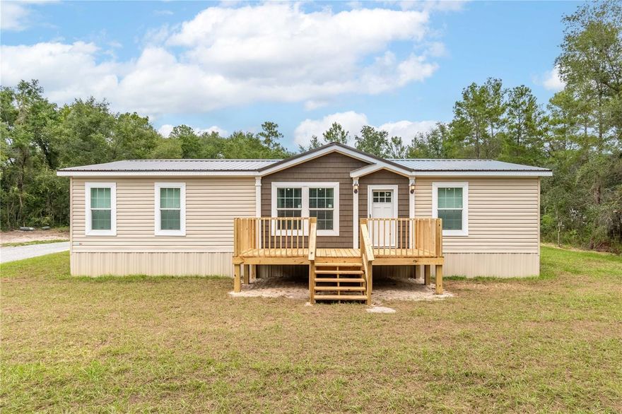 Freshly completed and never occupied, this pristine 2024 manufactured home is ready for its first owner! Fenced and gated on over 3 acres in the peaceful Island Lake Acres community, the property is offered fully furnished with brand-new furnishings throughout, perfect for a seamless move-in or immediate rental opportunity. The 3-bedroom, 2-bath split-bedroom layout offers 1,404 square feet of thoughtfully designed living space. Inside, you’ll find a bright open floor plan that features luxury vinyl flooring, lots of natural light, and modern finishes that combine comfort and style. The kitchen includes an eating nook and comes equipped with stainless steel appliances, a large center island with breakfast bar, and ample cabinet and counter space. A separate laundry area with washer and dryer is also included. Step outside to enjoy expansive outdoor living spaces, including a generous 10 x 32’ rear deck ideal for entertaining, grilling, or simply enjoying the quiet country setting, and an 8 x 18’ front deck perfect for making a first impression. The property's layout is ideal for those seeking room to breathe, create, or expand. A pole barn with water and power service is in place, including multiple electrical outlets, ideal for workshop use, vehicle or equipment storage, or future hobby farming. An additional storage shed also offers water and electrical hookups, making it highly adaptable for a range of uses. Utilities are fully connected, with a private well, septic system, electricity, and high-speed internet access available, and the zoning allows for flexibility with no HOA or deed restrictions to limit your plans. Located within walking distance of Island Lake and Pegram Lake, this property is an ideal option for those looking to spend time on the water. Lake Ocklawaha is also a short drive away, opening up larger options for fishing, boating, and exploration. This home offers a rare mix of modern convenience and rural privacy perfect for full-time living, a seasonal retreat, or even a fully equipped weekend getaway. With ample space, upgraded features, and all the essentials already in place, this is Florida country living at its most comfortable and convenient!