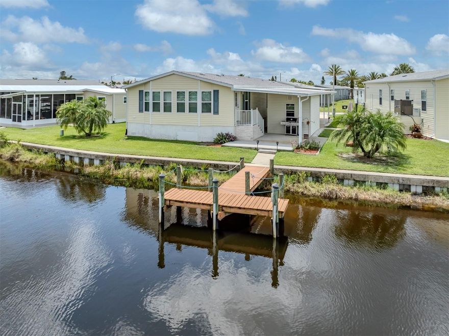 Welcome to this beautifully maintained 2008 manufactured home offering 1,700 sq ft of comfortable living space, situated directly on a tranquil canal with its own private dock in the highly sought-after 55+ waterfront community of Harbor Cove in North Port, Florida. This spacious 2 bedroom, 2 bathroom home features an expansive Florida/veranda room located at the rear of the home, fully under central air, with large windows that provide stunning canal views and fill the space with natural light.
The open-concept layout includes a generous living area with extra-wide hallways for easy accessibility. The kitchen is warm and inviting with hickory-colored cabinetry, abundant cupboard space, and two appliance garages, offering both charm and functionality. The oversized primary bedroom features a large walk-in closet and an ensuite bath with dual sinks. The guest bedroom also has a walk-in closet, and the laundry is conveniently located inside the home.
Recent updates include a shingle roof installed in 2022, a new AC system in 2021 with sanitized ducts and a 10-year warranty, and a hot water heater installed in 2017. For added stability, Intelli-jacks have been installed underneath the home to maintain a level foundation and ensure the tiedowns remain secure. Outside, enjoy a large covered patio in the back, a spacious shed with workbench, and all the essentials for Florida living. The home comes fully furnished and even includes a golf cart.
Harbor Cove is a vibrant 55+ resident-owned waterfront community with direct access to the Myakka River, Charlotte Harbor, and the Gulf of Mexico. Residents enjoy a full-service marina, boat ramp, kayak launch, two heated pools, hot tub, fitness center, tennis and pickleball courts, shuffleboard, and a clubhouse offering a wide variety of social activities and events. Pet ownership is restricted and permitted only in certain sections of the community with specific guidelines. Experience the Florida lifestyle in this move-in ready waterfront home.
