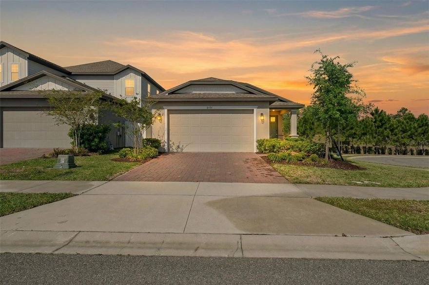 One or more photo(s) has been virtually staged. Set within the Hills of Minneola, this beautifully presented 3-bedroom, 2-bath home offers the combination of modern finishes, open living, and a homesite that feels larger and more open than many in the neighborhood. With its paver driveway, covered front porch, and clean architectural lines, the home delivers an immediate sense of quality and easy Florida living.Inside, the layout is bright, airy, and highly functional. The kitchen anchors the home with light cabinetry, stone countertops, stainless steel appliances, a decorative backsplash, and a large island that serves as both a natural gathering point and a practical workspace. It opens directly to the living and dining areas, creating the kind of connected floor plan buyers continue to seek. Wood-look tile flooring through the main living areas adds style and continuity, while the neutral palette makes the home feel fresh and move-in ready.

The bedroom layout offers separation and flexibility, with comfortable secondary bedrooms and a well-finished bath positioned apart from the main living areas. The primary suite provides a private retreat, and the interior laundry room adds to the home’s everyday ease.

Outside, the covered rear lanai overlooks a generous yard with additional breathing room created by the lot placement and surrounding open views. Whether you want room to unwind, entertain, or simply enjoy a less crowded feel, this homesite offers a real advantage.

Beyond the property itself, the Hills of Minneola continues to attract attention for its growth, elevated topography, and convenience to major roadways, shopping, and dining. Community amenities include a clubhouse, community pool, parks, and playgrounds, with a nearby K-8 school and easy access to medical facilities, the Florida Turnpike, Clermont, Winter Garden, and greater Central Florida.