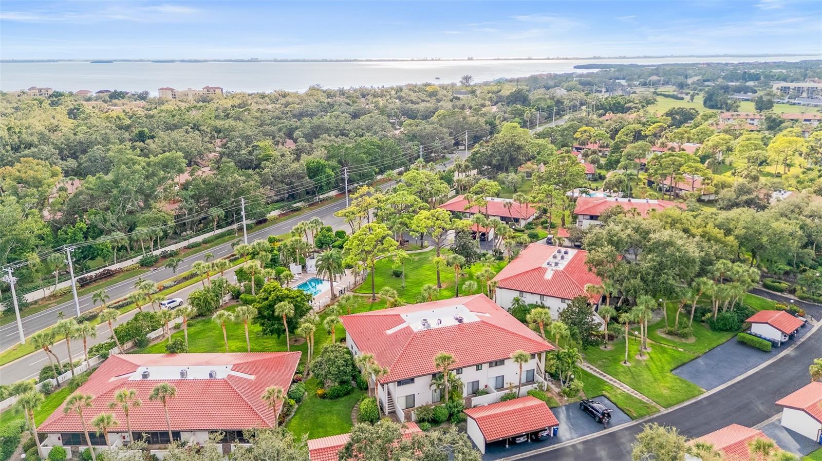 Short Sale. IMPACT SLIDERS............OVERLOOKING THE POOL AND COURTYARD........COVERED PARKING.......MINS FROM IMG ACADEMY.....SO CLOSE TO THE BEACHES..........There’s a special kind of calm that lives here. Maybe it’s the way sunlight dances across the bamboo floors, or how the pool sparkles just beyond your lanai, close enough to watch the kids play while you relax with a book and a breeze. Every day feels like vacation in this bright, end-unit condo that welcomes you with warmth and flow — from the open living area to the impact-rated sliding glass doors leading to your enclosed lanai overlooking the tropical courtyard and pool. The kitchen keeps things practical and inviting, with space that connects naturally to the heart of the home. The bedrooms are peaceful and filled with light, and the primary suite offers comfort with its private bath and double closets. You’ll appreciate thoughtful details like the full-size washer and dryer inside the unit, an updated electrical panel, new interior paint, and a newer roof that adds peace of mind. Step outside, and you’re surrounded by swaying palms and friendly faces in Valencia Gardens, where the pool, spa, and lush landscaping make it easy to slow down. Perfectly located just moments from IMG Academy, this home offers unmatched convenience for families, athletes, and visitors alike — and when the weekend arrives, Bradenton Beach and Anna Maria Island are just minutes away, close enough that you can almost feel the warm ocean breeze on your skin. Here, paradise isn’t just a place — it’s a feeling that greets you every time you come home.