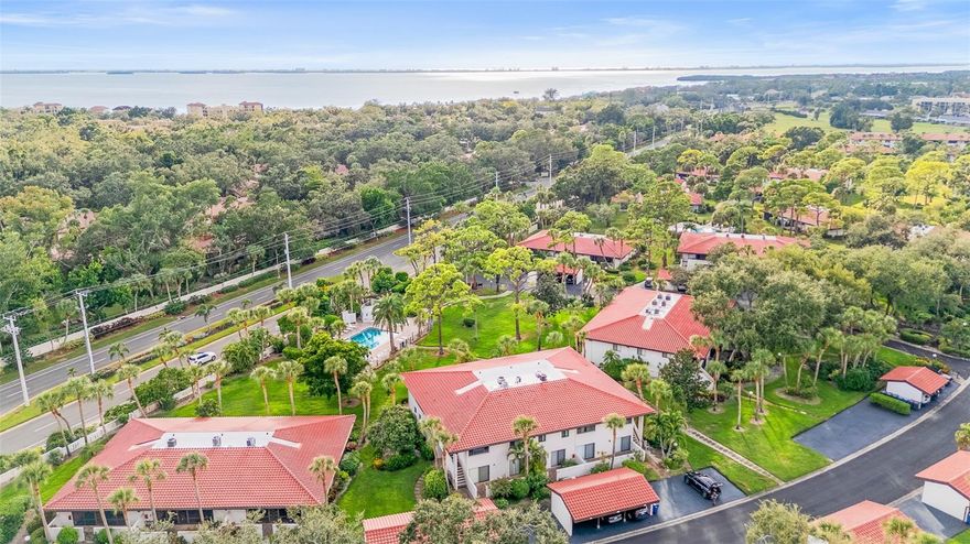 Short Sale. IMPACT SLIDERS............OVERLOOKING THE POOL AND COURTYARD........COVERED PARKING.......MINS FROM IMG ACADEMY.....SO CLOSE TO THE BEACHES..........There’s a special kind of calm that lives here. Maybe it’s the way sunlight dances across the bamboo floors, or how the pool sparkles just beyond your lanai, close enough to watch the kids play while you relax with a book and a breeze. Every day feels like vacation in this bright, end-unit condo that welcomes you with warmth and flow — from the open living area to the impact-rated sliding glass doors leading to your enclosed lanai overlooking the tropical courtyard and pool. The kitchen keeps things practical and inviting, with space that connects naturally to the heart of the home. The bedrooms are peaceful and filled with light, and the primary suite offers comfort with its private bath and double closets. You’ll appreciate thoughtful details like the full-size washer and dryer inside the unit, an updated electrical panel, new interior paint, and a newer roof that adds peace of mind. Step outside, and you’re surrounded by swaying palms and friendly faces in Valencia Gardens, where the pool, spa, and lush landscaping make it easy to slow down. Perfectly located just moments from IMG Academy, this home offers unmatched convenience for families, athletes, and visitors alike — and when the weekend arrives, Bradenton Beach and Anna Maria Island are just minutes away, close enough that you can almost feel the warm ocean breeze on your skin. Here, paradise isn’t just a place — it’s a feeling that greets you every time you come home.