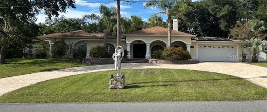 You will be amazed at the features this 2400+square foot home has at a price under 400K!!!  The curb appeal screams FIRST CLASS with a huge brick circular driveway sweeping up to a stately raised front porch, double door entry and oversized 2 car garage.  Upon entering the home, you will be amazed at the huge Living, Dining and entertaining areas.  There are three large bedrooms, four updated bathrooms, a home office/Bonus Room.  Two of the bedrooms are owner suites with one ideally set up for an in-law suite featuring a private entrance to the back yard courtyard. The Kitchen is completely updated and upgraded with newer cabinets granite counters, and new stainless-steel appliances.  Don't miss the views from the kitchen of your 29-foot-long screen enclosed lanai leading out to the humongous back yard with freeform, in-ground, solar heated, saltwater pool with paver deck and raised wood deck with covered eating area and covered outdoor kitchen.  Bring your green thumb if you wish because the homesite also includes your very own greenhouse, along with an attached she shed and a brand new 10x20 work shed all located in your fully fenced, double gated back yard where privacy abounds!!!  Recently replaced items include Solar hot water heater, well pump, new septic field and new whole house water filtration system.