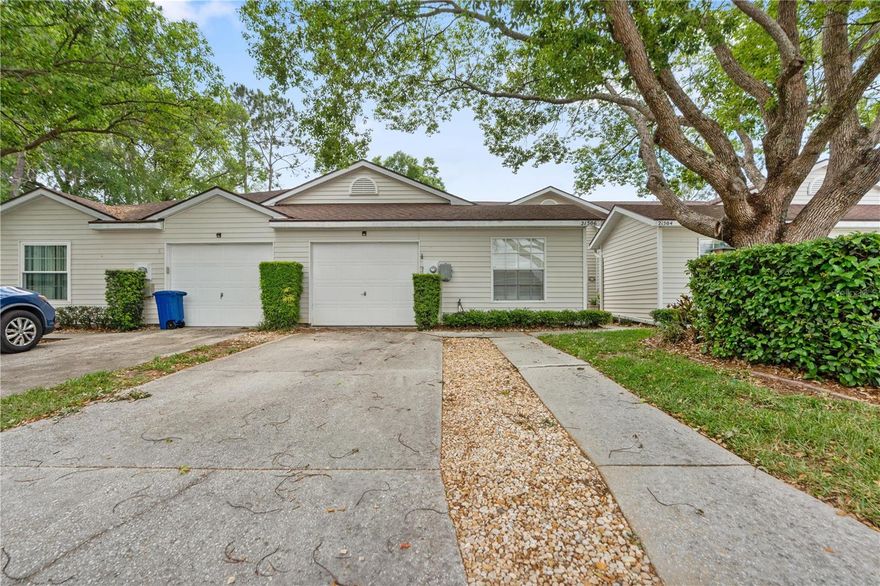 MAINTENANCE-FREE VILLA –LOW HOA and No flood insurance required in this X zone.    Welcome to this adorable and well-maintained 2-bedroom + den/office villa offering 1,288 sq. ft. of comfortable living space, perfectly situated on a quiet cul-de-sac in a tucked-away neighborhood surrounded by serene lakes in the desirable community of Lake Heron. . This home features a desirable split-bedroom floor plan, providing privacy and functionality, along with a versatile den that can easily be converted into a 3rd bedroom. The spacious interior showcases cathedral ceilings, architectural archways, plant shelves, and textured walls, creating character and charm throughout. The bright and airy living room is enhanced by skylights and a mirrored accent wall, bringing in natural light and an open feel. The kitchen offers abundant cabinet storage, decorative display shelving, rope lighting for added ambiance, a convenient breakfast serving area, and an eat-in space perfect for casual dining. Enjoy indoor-outdoor living with an enclosed back patio just off the family room—ideal for relaxing or entertaining. The primary bedroom is spacious and comes with its own bathroom with dual vanity, enclosed shower, private water closet and a walk in closet. Additional highlights include:New Lennox HVAC system, Tile flooring throughout for easy maintenance 1-car garage with additional parking for up to 3 vehicles Security system for added peace of mind Residents enjoy fantastic community amenities including a sparkling pool, tennis courts, and a clubhouse—perfect for social gatherings and an active lifestyle. There is also a dedicated storage lot available for work vehicles, trailers, and RVs, offering added convenience rarely found in villa communities. Location is everything, and this home delivers! Conveniently located near major highways for easy commuting, and just minutes from premier shopping, dining, and entertainment at Tampa Premium Outlets and The Shops at Wiregrass. Grocery stores, retail shops, and everyday conveniences are all nearby. This charming villa is priced to sell and offers low-maintenance living in a highly desirable area—don’t miss your opportunity!