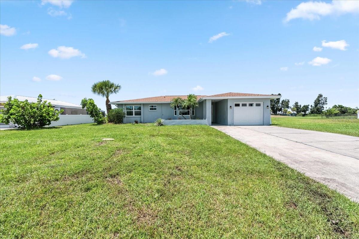 Fully remodeled home with golf and water views in the deed-restricted community of Rotonda West. This stunning home features a spacious open floor plan filled with natural light and wood-look plank tile flooring throughout—no carpet. The kitchen has been completely updated with quartz countertops, soft-close cabinetry, a stylish tile backsplash, and brand-new appliances. A large island provides additional seating and prep space, perfect for both entertaining and everyday living. The living and dining areas are open and inviting, offering a seamless flow for gathering and relaxation. Both bathrooms have been tastefully remodeled with modern finishes, and all bedrooms are generously sized with ample closet space. The home also includes an indoor laundry room with extra storage. Recent upgrades include a new roof in 2022 and hurricane-impact windows and sliding doors throughout. All new Electric AND Plumbing! HVAC only 3 years old! Step outside to your private Florida oasis: a brand-new pool cage encloses nearly 1,800 square feet of outdoor living space with new paver decking. The sparkling pool and expansive lanai are ideal for enjoying the sunshine, outdoor dining, or entertaining while taking in peaceful golf course and water views. Rotonda West offers five golf courses, walking and biking trails, boating, fishing, and is conveniently located near several beautiful Gulf beaches, shops, and restaurants.