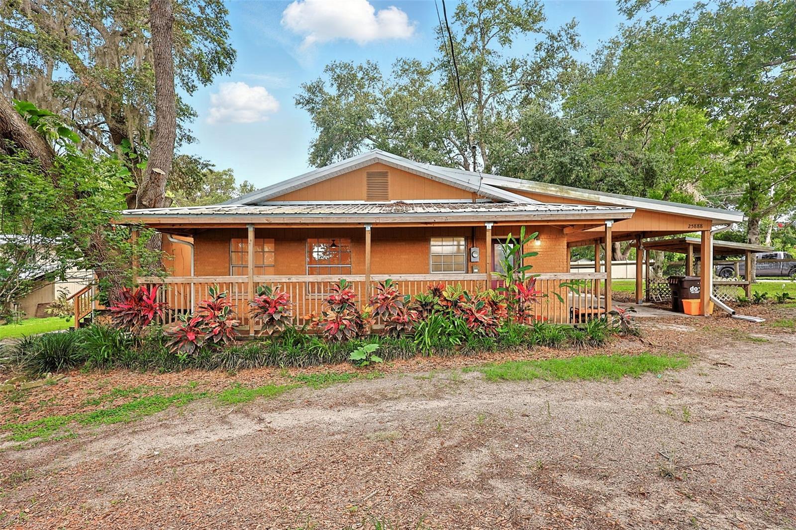 Experience the charm of country living on this spacious .86-acre lot, fully fenced for your privacy. This property features a large 20x20 workshop, with extra covered space perfect for storing boats, trailers, and equipment. The inviting open floor plan 2-bedroom, 2-bath home boasts large front and side porches, an updated kitchen with soft-close cabinets, sleek solid countertops, and a convenient breakfast bar. Embrace a relaxed rural lifestyle in this serene location that truly feels like home!
