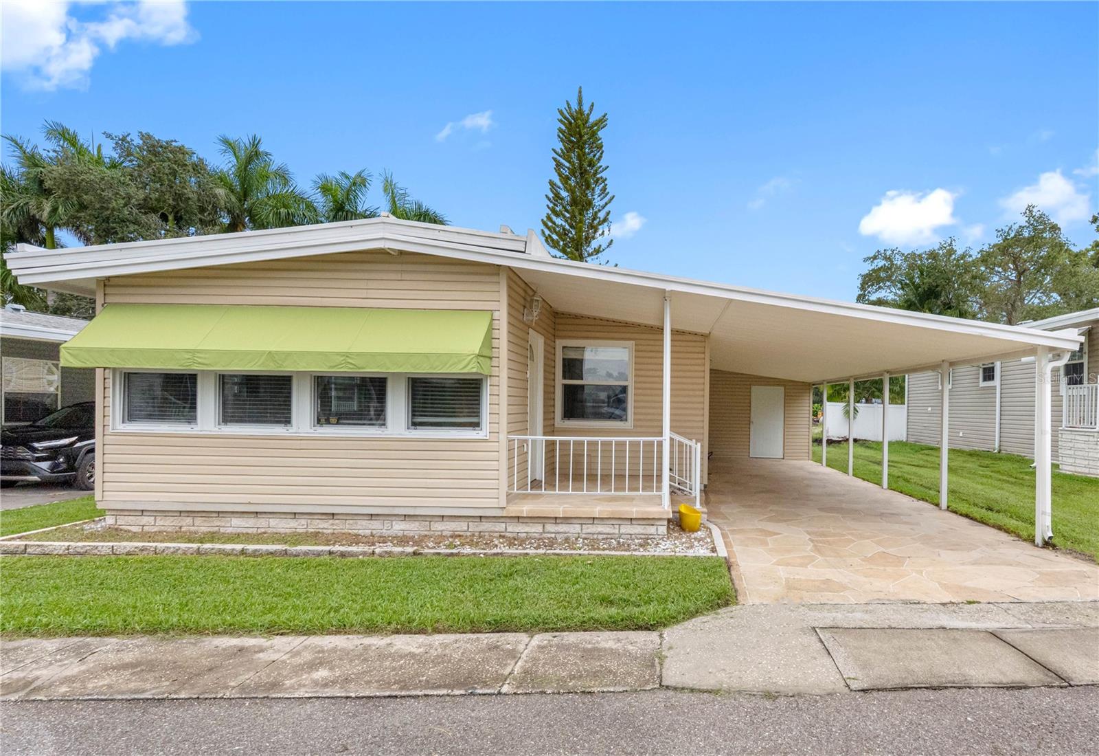 In the DESIRABLE, GATED 55+ PARK COMMUNITY of Doral Village, this FULLY REMODELED 2-bedroom, 2-bathroom home offers affordable living with the benefit of a resident-owned park, ensuring long-term stability and value for its homeowners. With NO LOT RENT and a low monthly maintenance fee of just $238, which covers water, sewer, lawn care, and garbage, this home combines comfort with cost efficiency. Spanning 1,004 square feet, the open floor plan has been thoughtfully updated throughout. The kitchen features STAINLESS STEEL APPLIANCES, NEW CUSTOM CABINETRY, and granite countertops. NEW PLUMBING, modern fixtures, and WATERPROOF LUXURY VINYL FLOORING add both function and peace of mind. The SPACIOUS PRIMARY SUITE offers a private bath with a walk-in shower, while the second bathroom includes a tub and new cabinetry. Additional highlights include a 2022 air conditioner, an extra wall unit in the bonus room, and a durable metal roof designed to last for many years. Practical features include a large two-car carport and an outside utility room. Step outside and enjoy the RESORT-STYLE AMENITIES of Doral Village, including a heated pool, hot tub, shuffleboard, billiards, and a wide array of social activities such as golf, bowling, card games, dances, and travel outings. This pet-friendly community is ideally located near golf courses, beautiful beaches, shopping, dining, medical facilities, and just 30 minutes to two major airports. Move-in ready and beautifully renovated, this home offers a vibrant, active lifestyle in one of the area’s most sought-after 55+ communities.