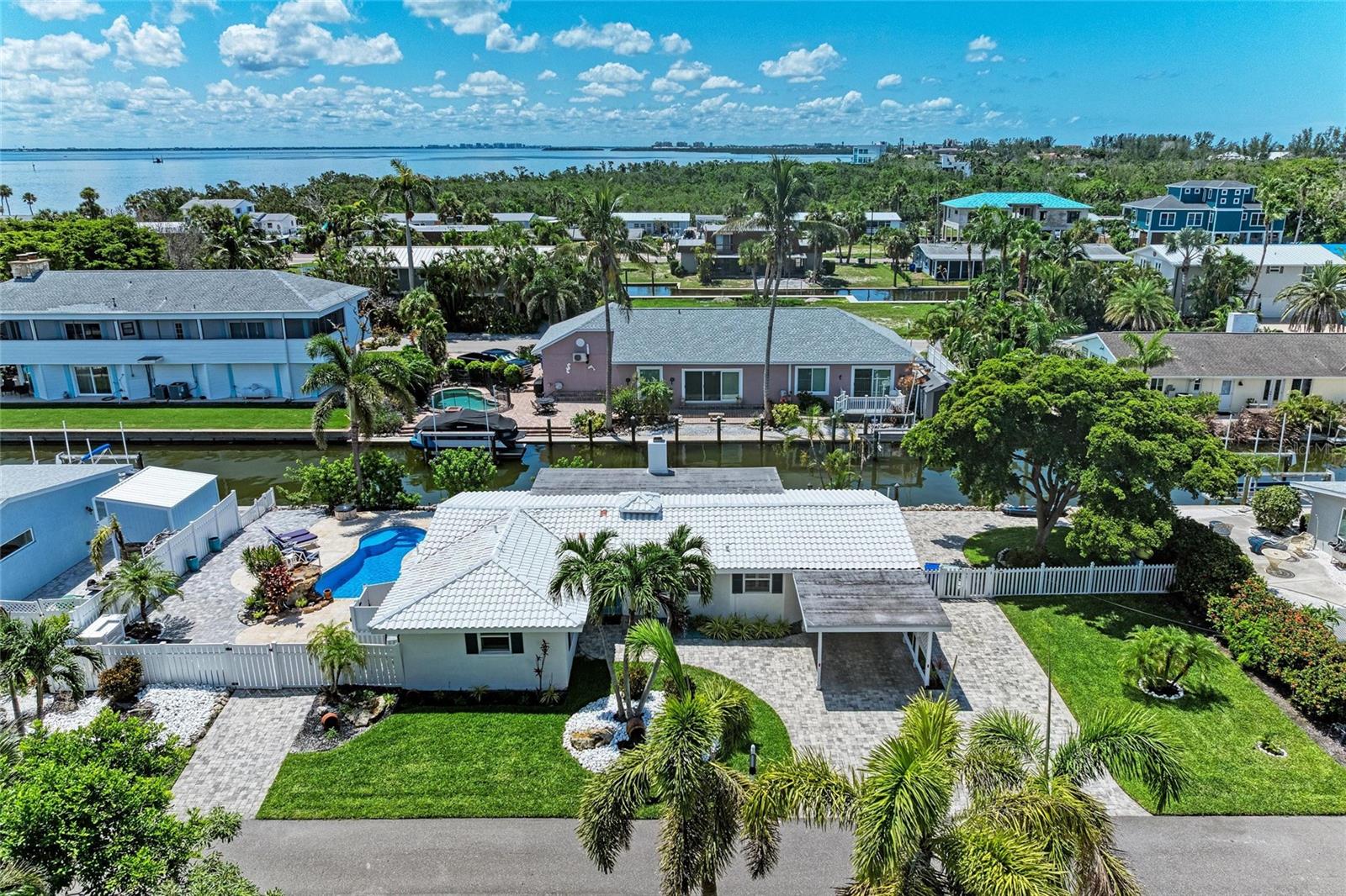 Waterfront Paradise on Longboat Key – Deeded Beach Access + Private Pool + Private Dock! Welcome to your dream coastal retreat! This fully renovated 2 bedroom, 2 bath canal-front home on Longboat Key is the ultimate blend of luxury, comfort, and convenience. Nestled just steps from 10 miles of pristine Gulf beaches—with deeded beach access—you’ll enjoy the best of both water worlds: boat out back, beach up the block. Bring your boat and dock it with ease—this property includes private dock pilings on a deep-water canal. After a day on the water, take a dip in your saltwater swimming pool surrounded by elegant travertine and brick pavers, rinse off in the outdoor shower, and unwind fireside on your expansive pool deck, enjoying tranquil evenings under the stars. The interior exudes coastal sophistication with thoughtful upgrades throughout: plantation shutters, a stunning oversized tile fireplace, a beautifully redesigned kitchen and baths, and a cozy wood-burning fireplace in the family room that overlooks the canal. Recent upgrades include a new HVAC system (2019), fresh interior paint, new baseboards, new interior doors, and a total professional flood mitigation—complete with new drywall, and rewired electrical. This home sits on a beautifully landscaped lot with a paver driveway and covered carport. Every detail has been handled—just move in and start living the Longboat Key lifestyle. Enjoy easy access to island shopping, top-rated restaurants, dog-friendly parks, and charming local boutiques. Just minutes to St. Armands Circle, Sarasota, Anna Maria Island, and Bradenton. Boater’s dream. Beach lover’s paradise. Island living at its finest. Don’t miss this rare opportunity—schedule your private tour today!