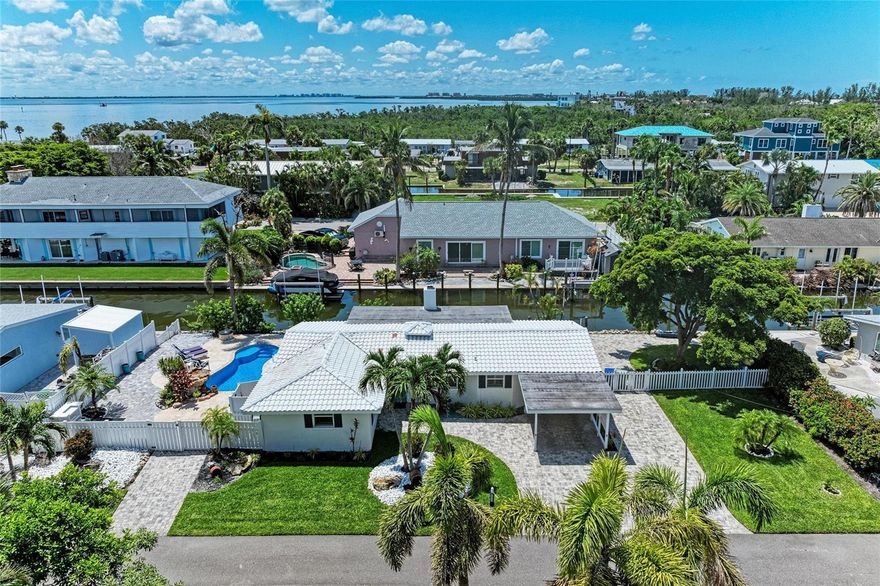Waterfront Paradise on Longboat Key – Deeded Beach Access + Private Pool + Private Dock! Welcome to your dream coastal retreat! This fully renovated 2 bedroom, 2 bath canal-front home on Longboat Key is the ultimate blend of luxury, comfort, and convenience. Nestled just steps from 10 miles of pristine Gulf beaches—with deeded beach access—you’ll enjoy the best of both water worlds: boat out back, beach up the block. Bring your boat and dock it with ease—this property includes private dock pilings on a deep-water canal. After a day on the water, take a dip in your saltwater swimming pool surrounded by elegant travertine and brick pavers, rinse off in the outdoor shower, and unwind fireside on your expansive pool deck, enjoying tranquil evenings under the stars. The interior exudes coastal sophistication with thoughtful upgrades throughout: plantation shutters, a stunning oversized tile fireplace, a beautifully redesigned kitchen and baths, and a cozy wood-burning fireplace in the family room that overlooks the canal. Recent upgrades include a new HVAC system (2019), fresh interior paint, new baseboards, new interior doors, and a total professional flood mitigation—complete with new drywall, and rewired electrical. This home sits on a beautifully landscaped lot with a paver driveway and covered carport. Every detail has been handled—just move in and start living the Longboat Key lifestyle. Enjoy easy access to island shopping, top-rated restaurants, dog-friendly parks, and charming local boutiques. Just minutes to St. Armands Circle, Sarasota, Anna Maria Island, and Bradenton. Boater’s dream. Beach lover’s paradise. Island living at its finest. Don’t miss this rare opportunity—schedule your private tour today!