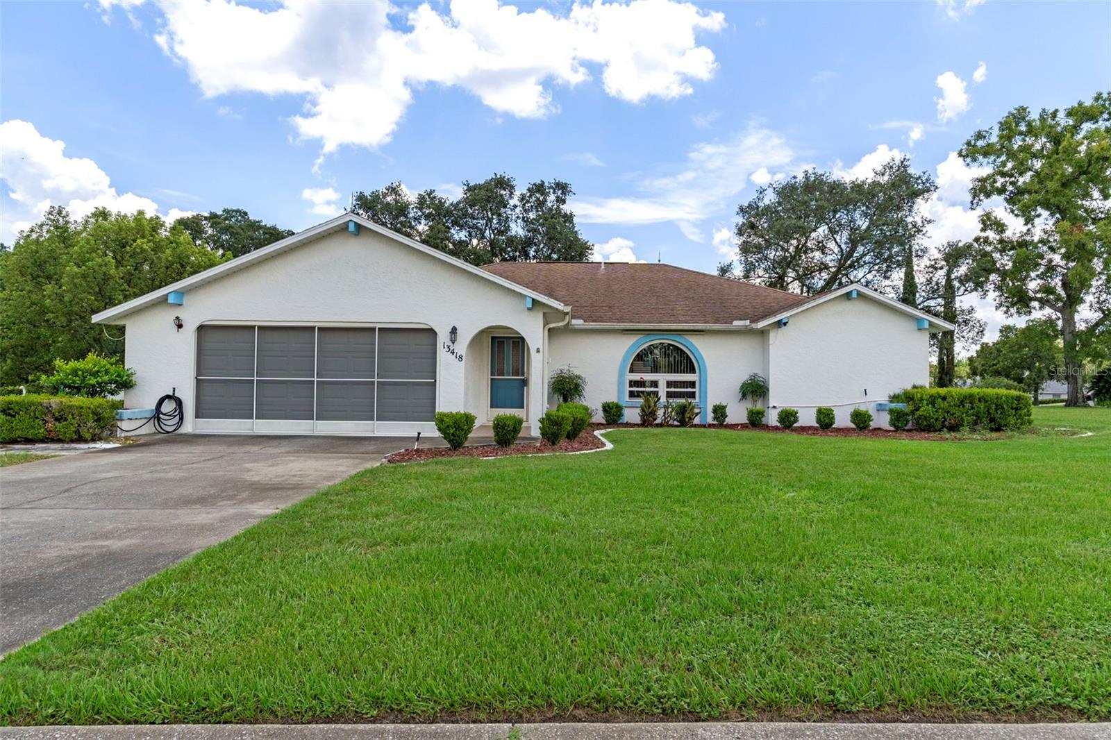 Nestled in the heart of Hernando County, this well-maintained 3-bedroom, 2-bathroom home sits proudly on a spacious corner lot of over half an acre in the desirable community of The Oaks. With a low annual HOA cost and an unbeatable location, this property offers the perfect blend of comfort, charm, and convenience. From the moment you arrive, you'll be captivated by the stunning curb appeal, featuring matured landscaping and decorative curb-a-lawn edging along each flowerbed. A 15-foot-long entry foyer welcomes you into the home, leading to a spacious 19x15 living room with cathedral ceilings, soft carpeting, and a beautiful arched bay window that fills the space with natural light. Arched entryways create an elegant flow into the formal 13x11 dining room, complete with chair rail accents and sliding glass doors that open to a generous 23x10 screened rear porch—ideal for relaxing or entertaining. The 12x11 kitchen is designed with functionality in mind, offering abundant countertop and cabinet space, a breakfast bar, and a separate 11x6 breakfast nook for casual dining. The split-bedroom layout provides privacy for the primary suite, which measures 17x14 and features carpet flooring, a large walk-in closet, an en-suite bathroom with a tiled walk-in shower equipped with handicap railings, a spacious vanity, linen storage, and direct access to the screened porch. Both guest bedrooms measure 12x11, offering generous closet space and are conveniently located near the full guest bathroom with a large vanity and tub/shower combination. Additional features include a 6x6 interior laundry room with wire shelving located just off the garage, and a 22x20 screened two-car garage with pull-down attic stairs, a laundry tub, a service door, and a dedicated workbench area with additional shelving for storage. The backyard includes a 10x10 open patio, perfect for outdoor dining or enjoying the Florida sunshine. Practical upgrades such as an irrigation system with well, installed grounding rods for lightning protection, and a security system add peace of mind. This is more than just a house—it's a place to call home. Don't miss your opportunity to live in one of Spring Hill's most established neighborhoods.
