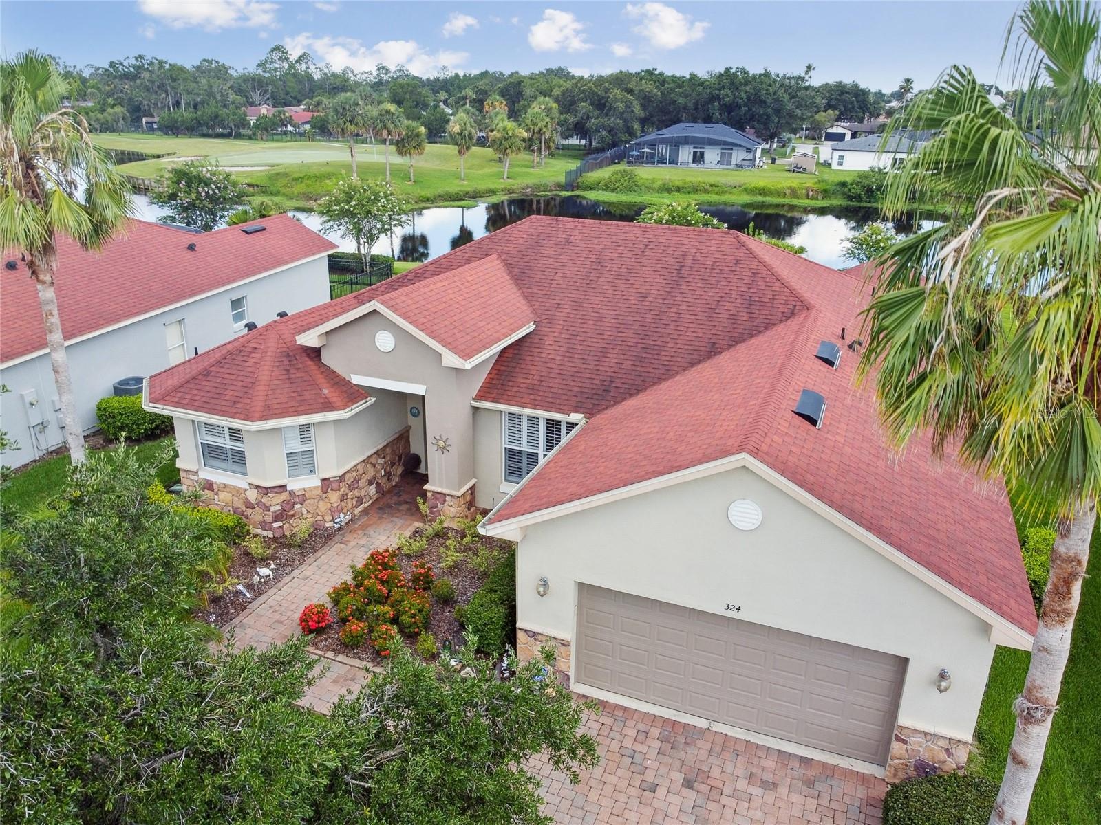 WATER and GOLF VIEWS await you in this stunning Carnegie model, featuring a welcoming LEADED GLASS front door with transom window. ROOF was replaced in 2016. HVAC 2020. NEW HWH installed in 2024. Step inside to an elegant living and dining room combination featuring 18" TILE ON THE DIAGONAL and CROWN MOLDING! This 2-bedroom, 2-bath home features a flexible Florida room with sliders out to the lanai—perfect as a TV room, home office, or just a cozy spot to unwind and enjoy the views. The kitchen is a chef’s delight, showcasing solid wood 42-inch cabinets with GLASS-FRONT accents, convenient PULL -OUT DRAWERS, Zodiac quartz countertops, recessed lighting, and a stylish breakfast island with a custom tile wall front. The eat-in nook adjacent to the island offers a perfect spot for casual dining. PLANTATION SHUTTERS and doors add a touch of style throughout the home. All bedrooms are carpeted, with the PRIMARY SUITE positioned on one side of the home for added privacy. The suite features double door entry and includes two spacious walk-in closets—one with custom built-ins and a wall-mounted jewelry case—a linen closet, and FRENCH DOORS that open right out to the covered lanai, perfect for stepping out and enjoying some fresh air. The attached ENSUITE BATH offers a soaking tub, a WALK-IN SHOWER, raised vanities, DUAL SINKS, a dedicated makeup vanity area, and a separate commode room. The additional second bedroom and full bath are ideal for hosting guests, providing comfort and privacy during their stay. The COVERED SCREENED AND EXTENDED lanai features stamped concrete floors and stunning views of the golf course and water—perfect for relaxing or entertaining friends. Sliders from the living room, family room and eat-in nook, make it easy to enjoy indoor-outdoor living. There's also a SIDE PATIO just right for your barbecue grill and casual get-togethers. The separate laundry room includes a BUILT-IN OFFICE AREA with storage cabinets, creating a functional and efficient space.The two-car garage includes a convenient UTILITY SINK. The STONE FRONT VENEER gives the home a warm, welcoming feel and adds to the great curb appeal. Enjoy resort-style living in an award-winning community designed for your best active years. With so much to offer, now’s the perfect time to make your move—call today to schedule your private tour!!! Solivita's amenities include: a manicured SOFTBALL diamond & field - 36 holes of CHAMPIONSHIP GOLF that can be played by joining the Stonegate Golf Club or paying as you go - 2 STATE of the Art AMENITY centers with updated exercise equipment, yoga studio & meeting rooms, 3 restaurants, 14 HEATED POOLS, 17 PICKLEBALL courts, 9 TENNIS courts, 4 BOCCE BALL courts miles of bike paths, 2 DOG PARKS (Small & Large Dogs), Corn Hole and so much more! The HOA: - maintains the LANDSCAPING & IRRIGATION systems in the common areas as well as at individual homesites - maintains the roads throughout the community, PROVIDES SECURITY with gate guards and mobile patrols including the Polk County Sheriff - allows AUTOMATED GATE ACCESS for residents via license plate readers - provides residents with Fiber Optic Internet & TV service.***Poinciana Lakes Plaza is a MAJOR NEW SHOPPING CENTER that opened directly across from the Solivita Main Gate in Summer of 2024. It features Sprouts Grocery, TJ MAXX, Ross, Burlington, Rack Room Shoes, Ulta, Outback, First Watch, 5 Guys, Urgent Care, Dentist, TD Bank, Petco & Hair Cuttery PLUS MORE TO COME!