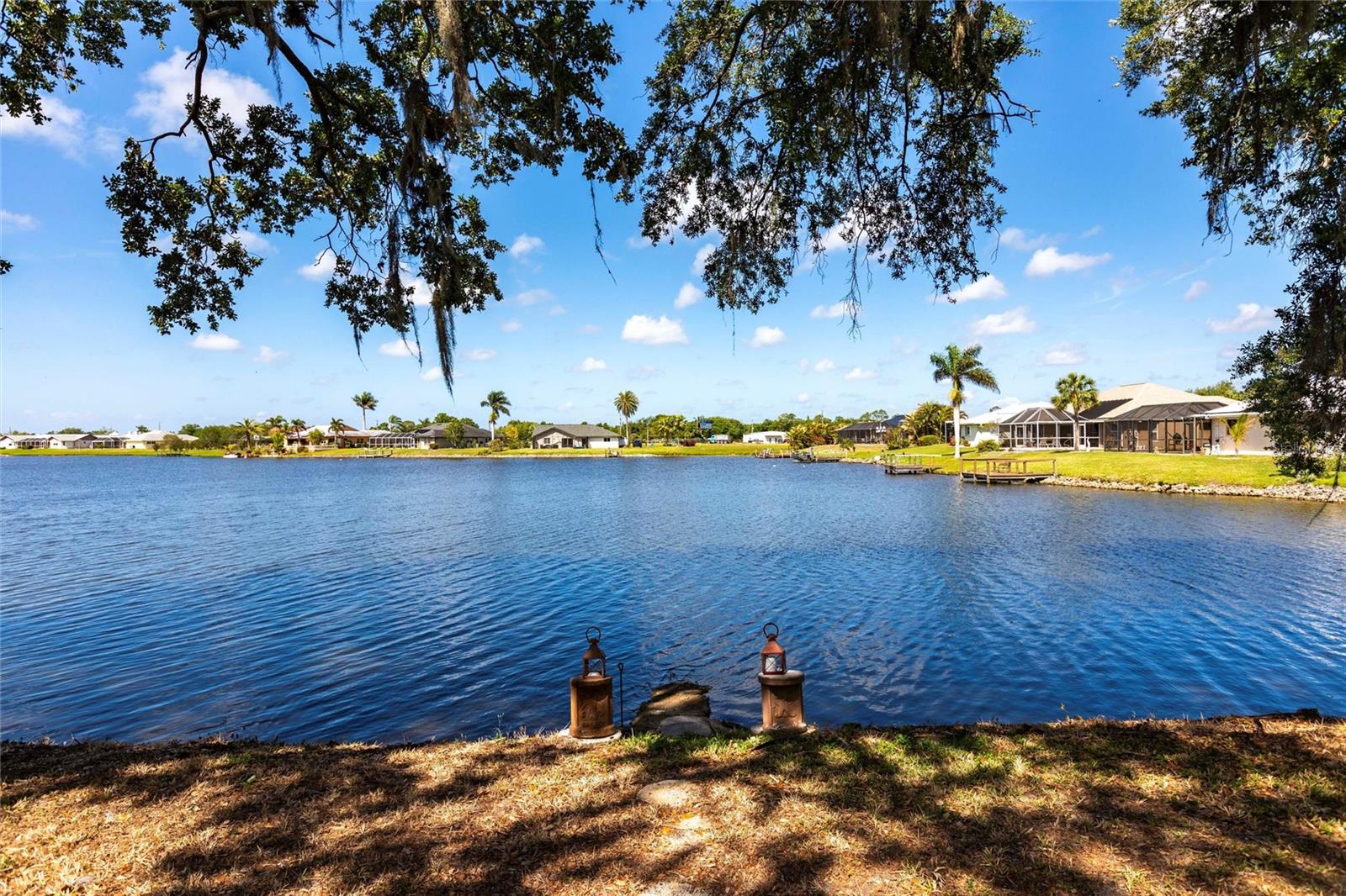 Lakefront Living at Its Finest – Updated Dual Master Suite Home on Nearly Half an Acre! BONUS: NOT IN A FLOOD ZONE
Every day feels like a vacation in this beautifully updated, Mediterranean-style home nestled under majestic oaks with 91 feet of serene lakefront on Lake Suzy. Enjoy breathtaking sunset views from your expansive screened lanai—pure peace and privacy with no rear neighbors.
Step inside to discover a spacious and inviting layout with two master suites—perfect for hosting guests or multigenerational living. This home has been thoughtfully updated with major improvements including a NEW ROOF (2022), NEW A/C (2018), NEW WATER HEATER, and NEW SEPTIC SYSTEM for peace of mind.
• The interior blends warm, sun-drenched charm with modern comforts:
• Soaring ceilings & skylights fill the space with natural light
• Luxury vinyl plank flooring throughout the main living areas
• A stunning galley-style kitchen with granite counters & backsplash, timeless shaker cabinetry, and abundant storage
• Cozy family room & bonus dining nook for everyday living and entertaining.
Both bedrooms are generously sized, with the primary suite featuring a spa-like bath, soaking tub, walk-in shower, and dual vanities. The second suite offers its own lanai access, full bath, and walk-in closet—ideal for long-term guests or additional family.
Outdoors, unwind on the private front patio with open-beamed ceiling or take in the tranquil lake views from the back. The oversized lot offers endless potential—room to garden, relax, or even add a pool.
Located just minutes from I-75, shopping, dining, and beaches—this is the rare blend of privacy, beauty, and convenience.
Homes like this don’t come around often—schedule your showing today and experience Lake Suzy living for yourself! **PLEASE ENJOY THE 3D INTERACTIVE VIRTUAL TOUR ASSOCIATED WITH THIS LISTING**