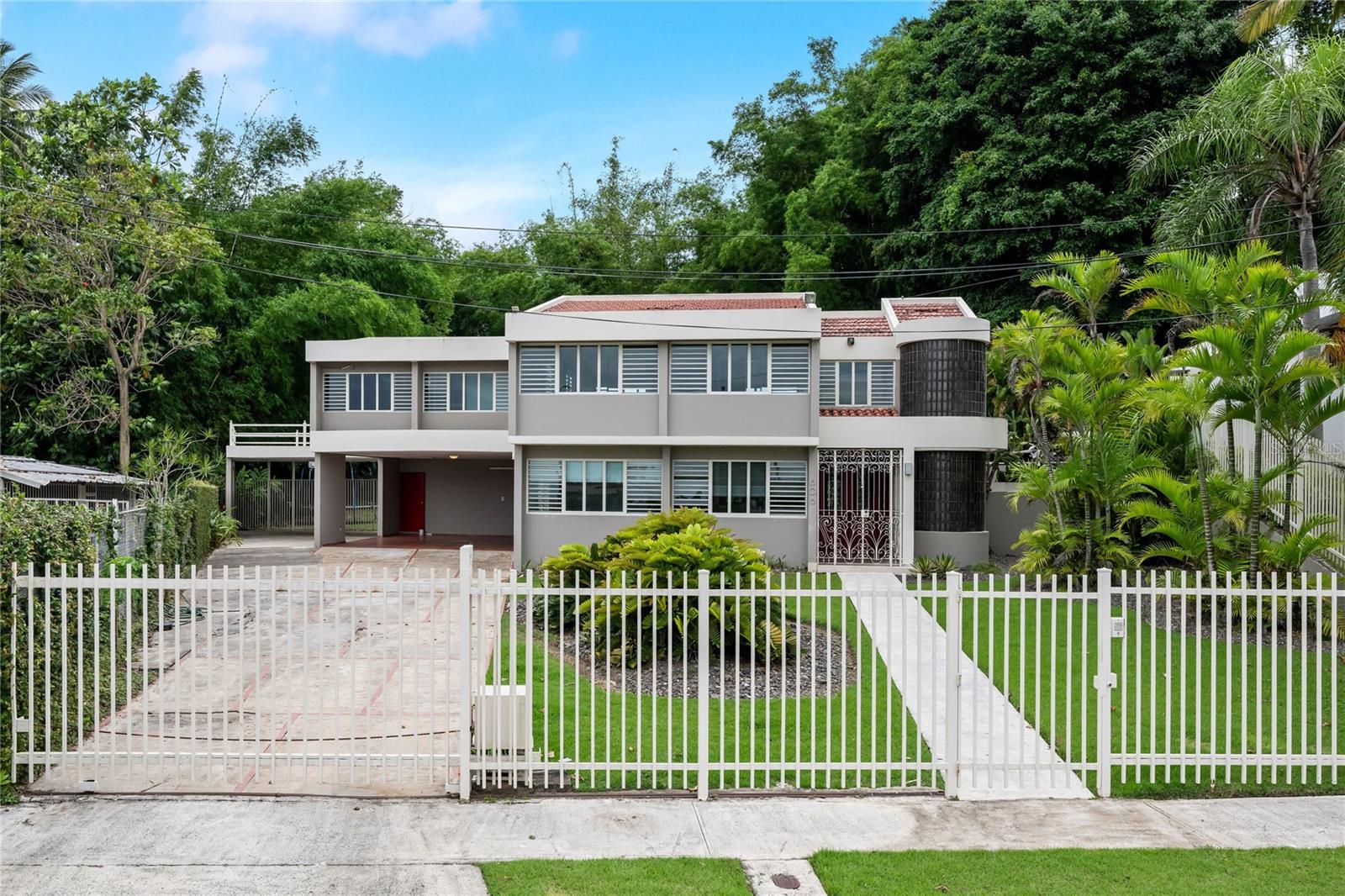 This residential property showcases a stunning contemporary design, spread across two levels and featuring an impressive backyard complete with a swimming pool. Having undergone a complete remodel in the 90s, the home boasts approximately 3,305 sq. ft. of living space situated on a generous 1,075 sq. meter lot.
Key highlights include:
- **Living Space**: 4 bedrooms and 4 bathrooms, along with an additional home office and a large laundry room located on the second floor.
- **Master Suite**: Spacious master bedroom equipped with a large walk-in closet and a luxurious bathroom featuring a spacious shower, toilet, bidet, and vanity.
- **Kitchen**: A modern kitchen with stainless steel appliances.
- **Outdoor Spaces**: A concrete terrace measuring around 900 sq. ft., spacious enough for gatherings, with a bar, storage space, and an exterior full bathroom. There's direct access from the terrace to the living, family, and kitchen areas.
- **Garage**: Two covered garages with a total capacity for 4 cars, with one conveniently located next to the kitchen entrance.
**Finishes and Equipment**:
- Marble floors in main living areas
- Split A/C units for climate control
- Security windows and doors for enhanced safety
- Water cistern and full power generator for convenience
- Alarm system for added security
**Community Amenities**:
- 24-hour gated community access
- Recreational and sports park nearby